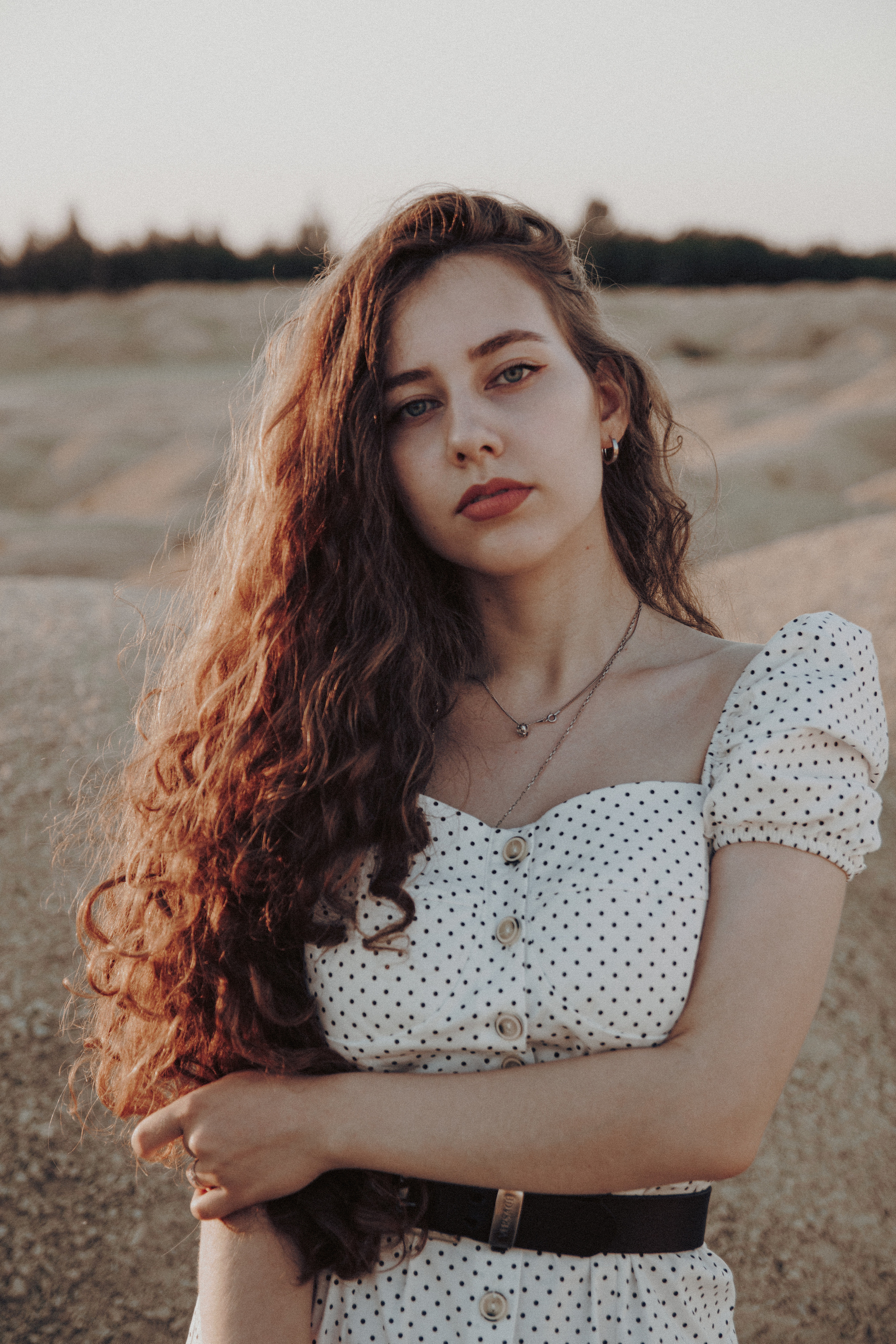 Портрет красивой девушки в белом платье на фоне песчаного карьера