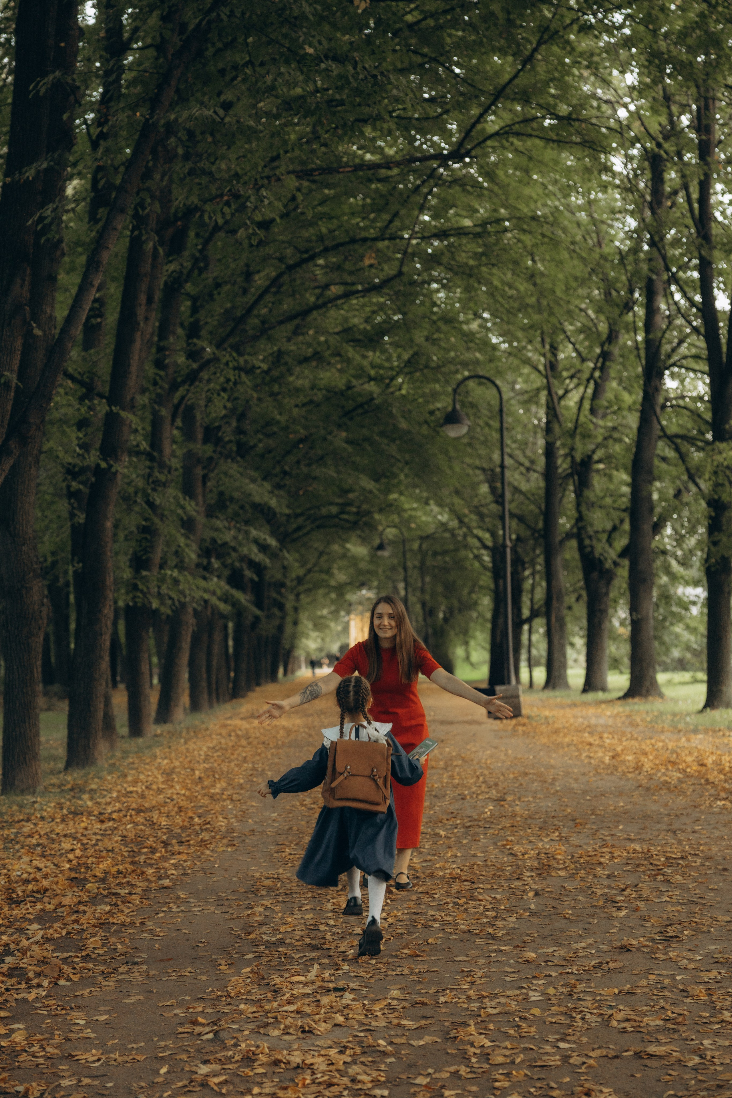 Девочка первоклассница бежит в парке к маме