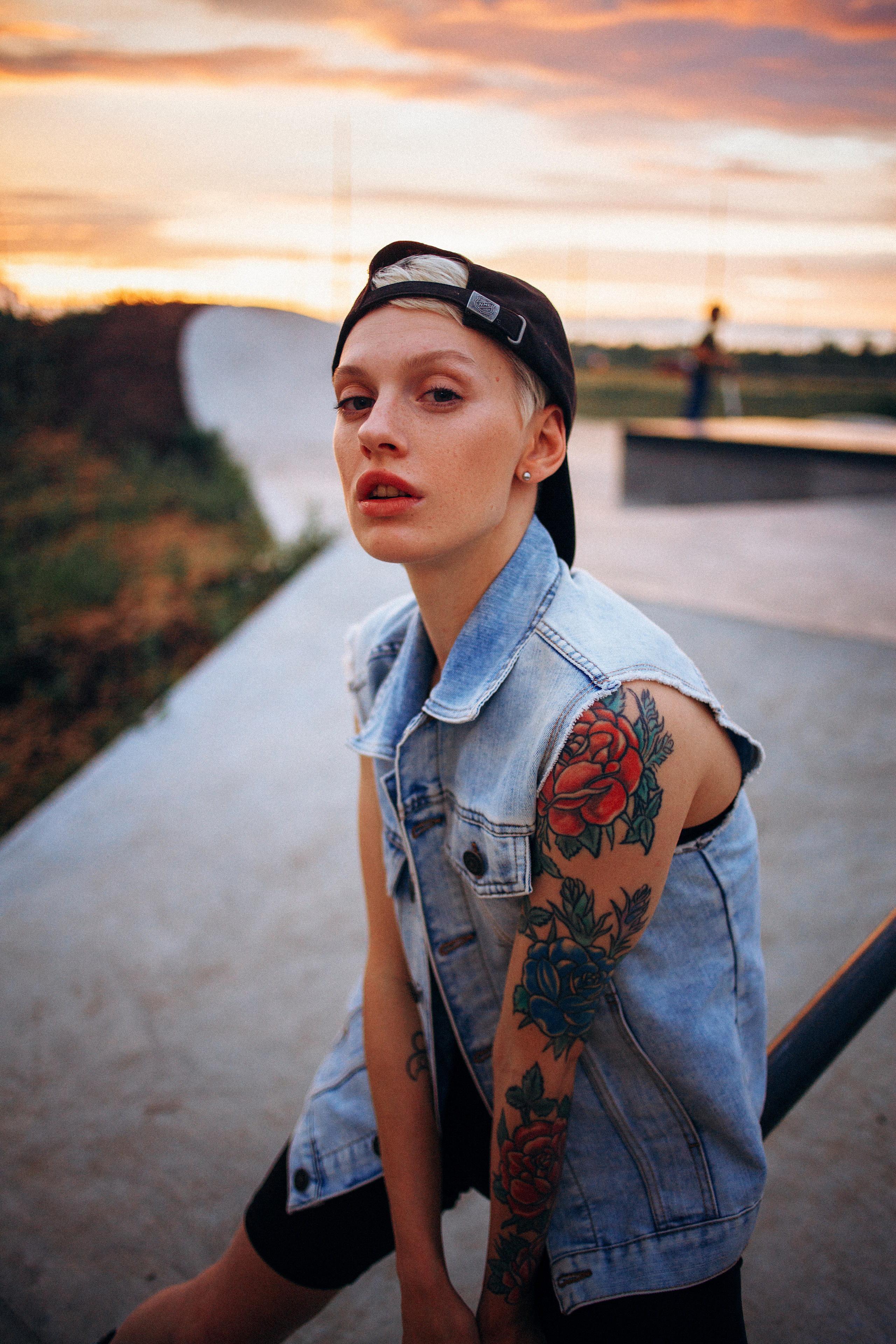 Девушка на закате в скейт-парке в бейсболке и джинсовке