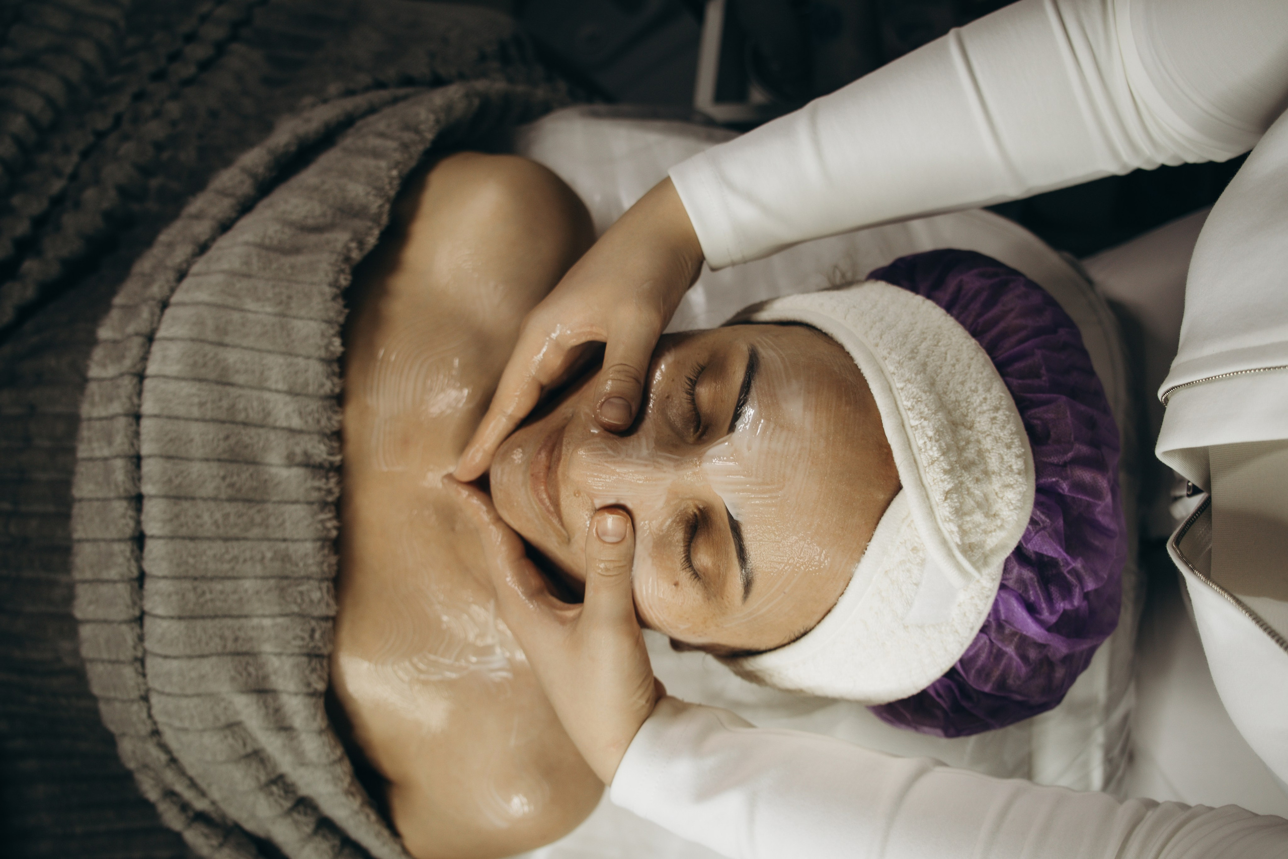 Косметолог наносит сыворотку, крупный план 