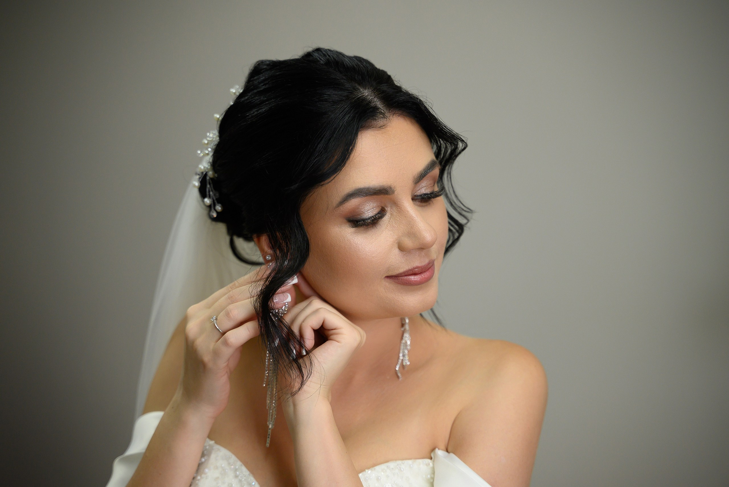 Невеста надевает серьги.