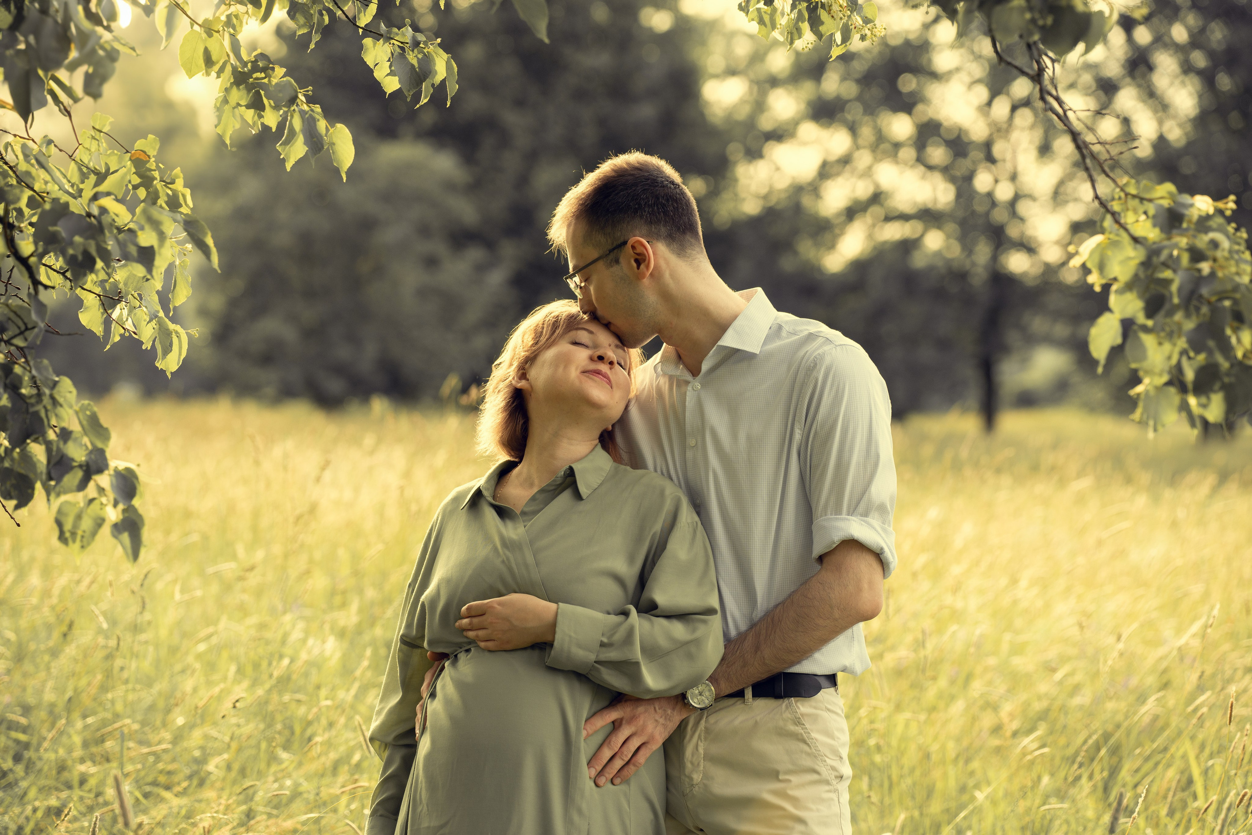 Беременная девушка с мужем в парке