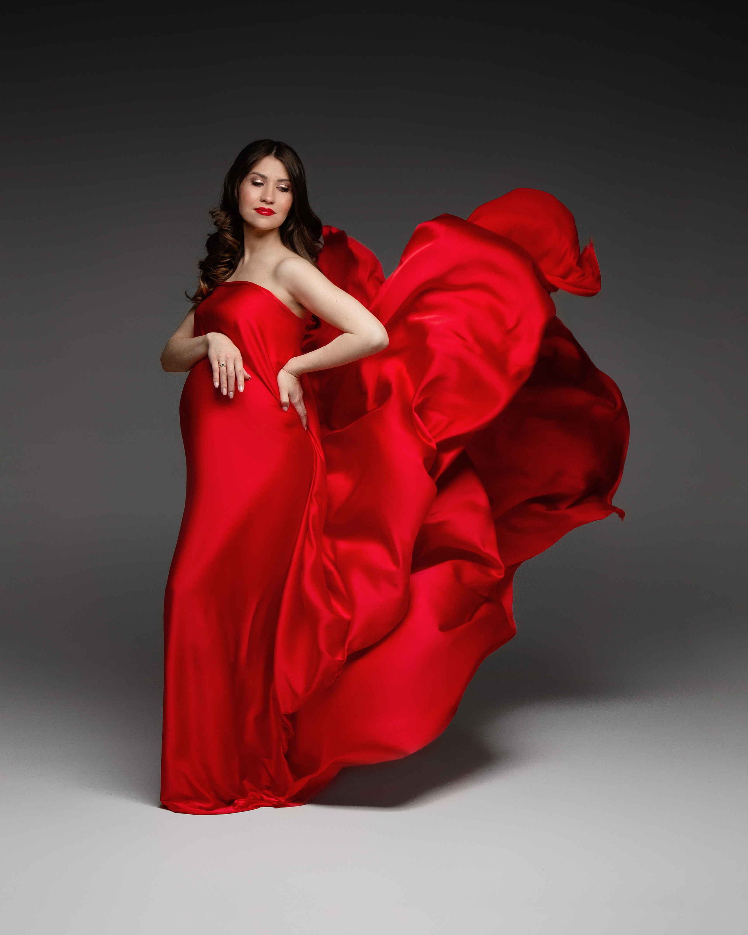 Беременная девушка в красной ткани