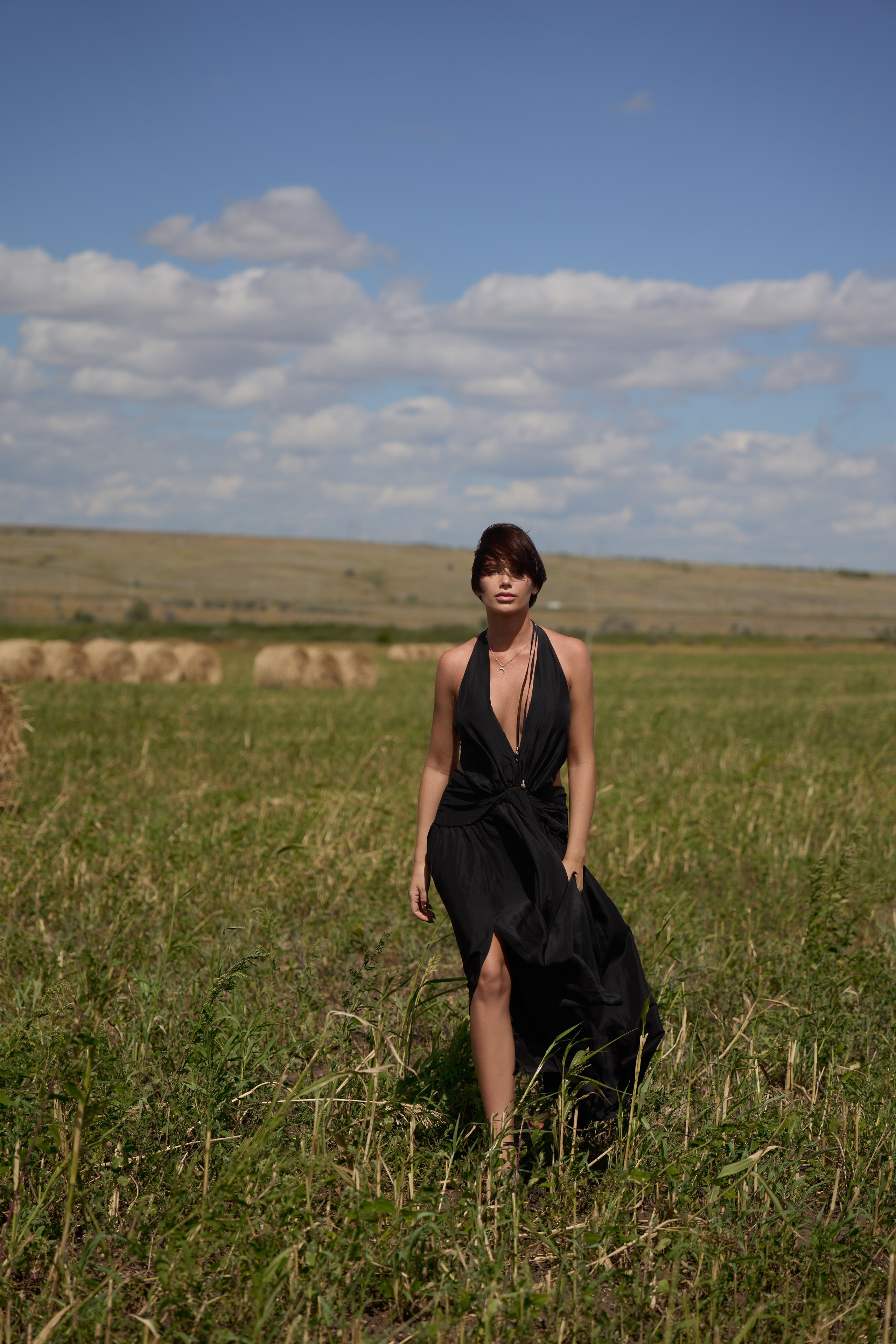 На этом фото с прогулочной фотосессии прекрасная девушка в развевающемся черном платье. Снято в полях Саратова со стогами сена. Фотограф Саратов - Москва