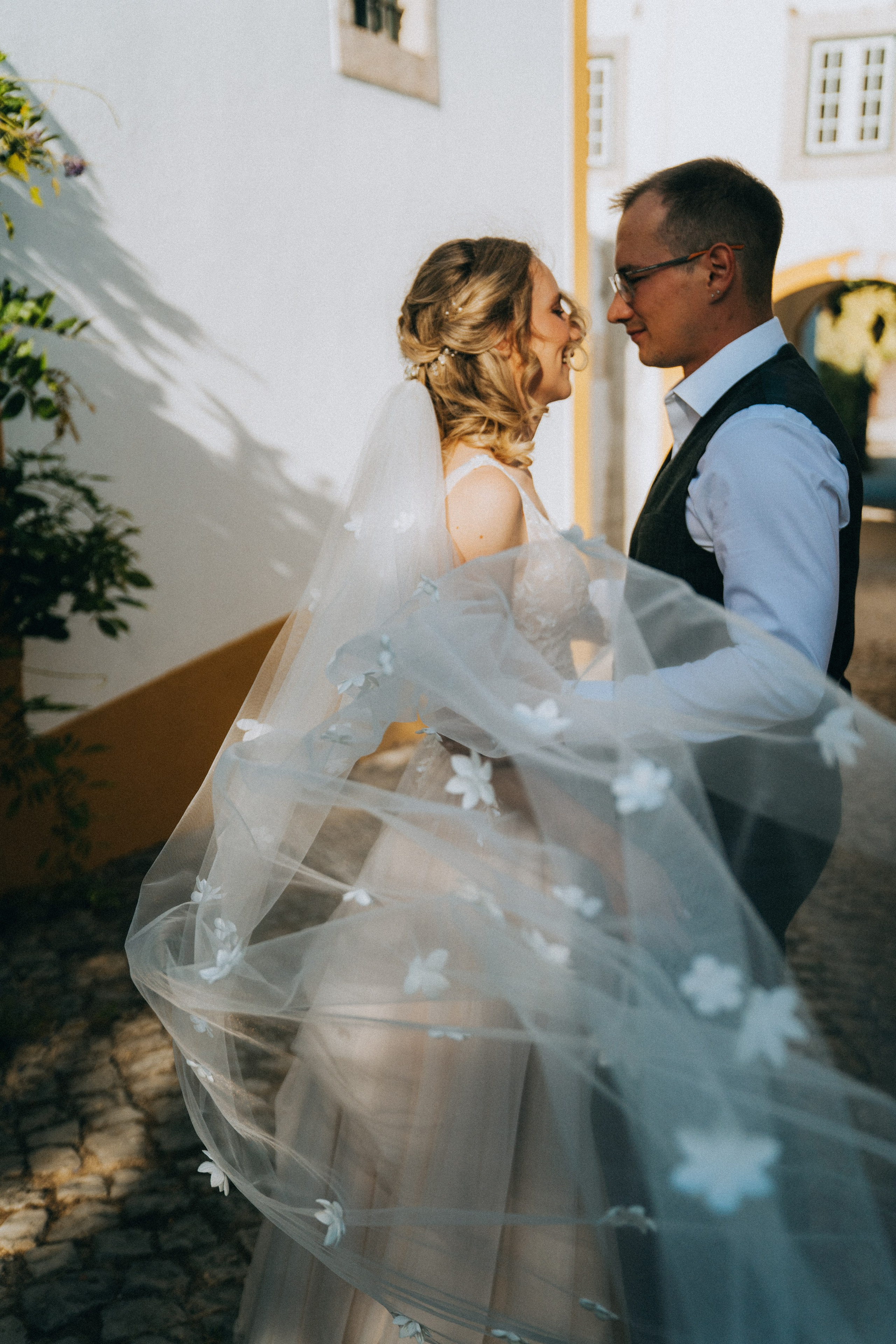 Влюбленная  пара жених и невеста целуется и обнимаются на фоне старинных улочек Португалии