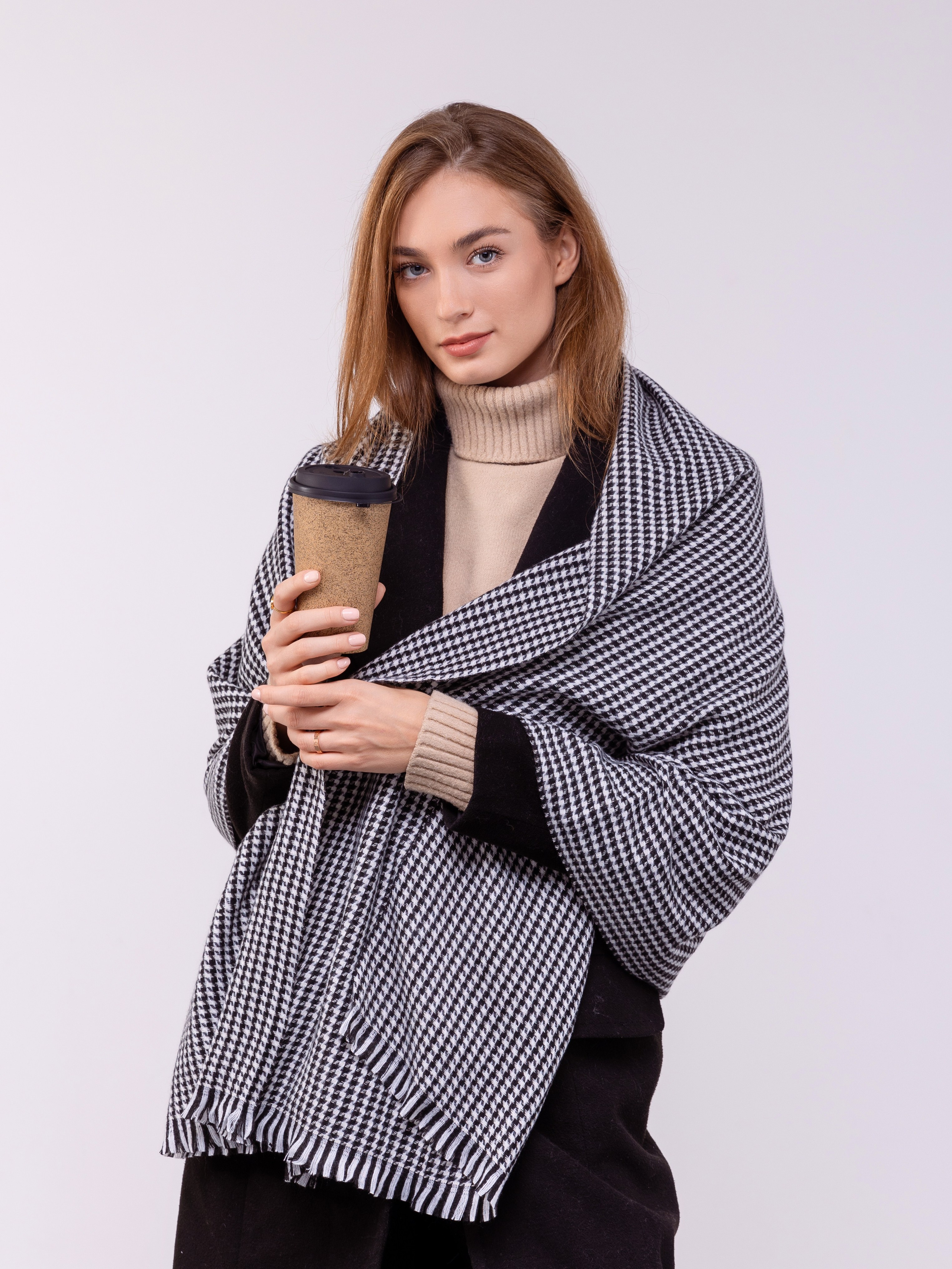 Девушка рекламирует палантин в мелкую клетку.