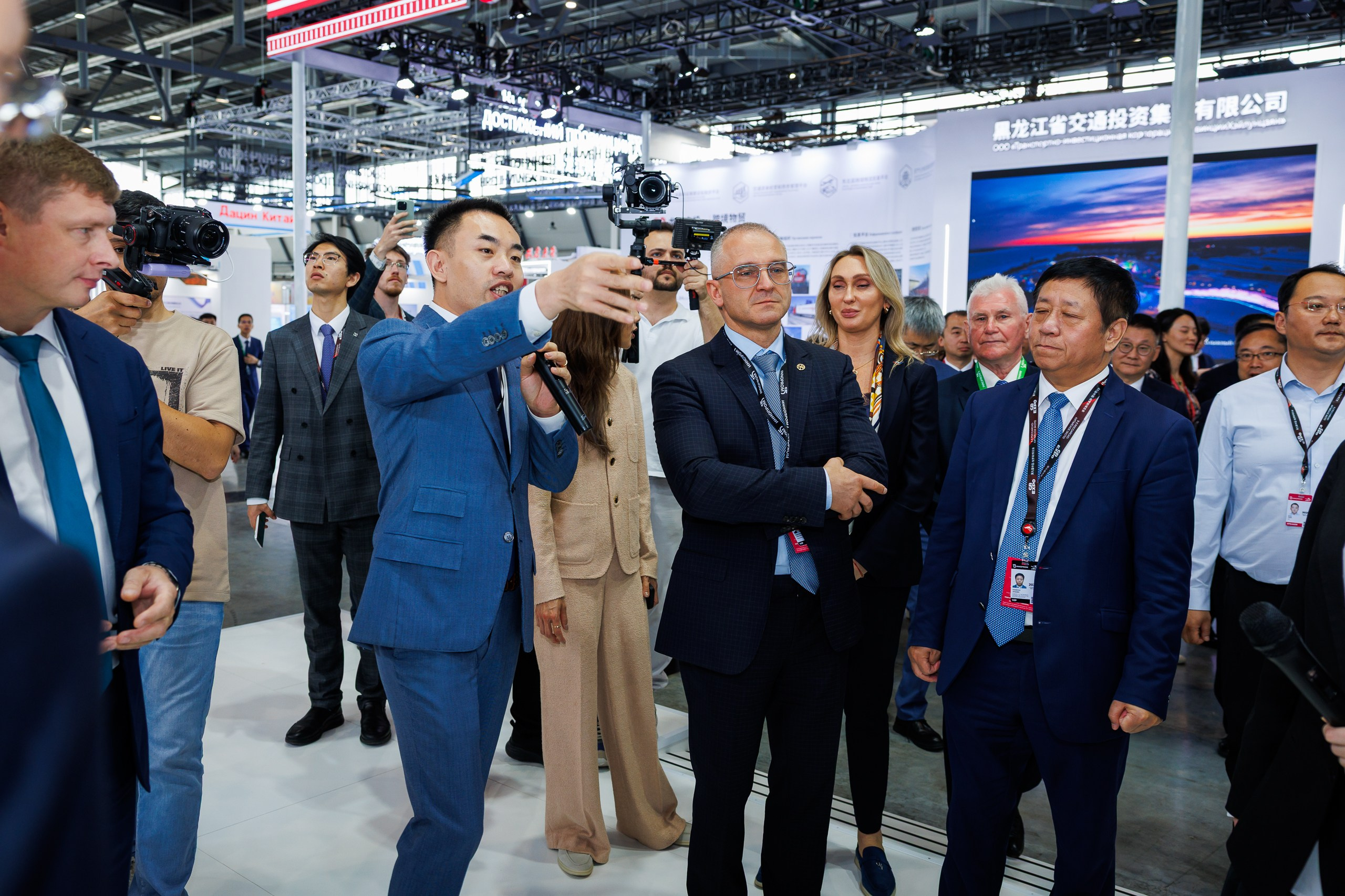 Фотограф снимает презентацию строительных материалов посетителям выставки