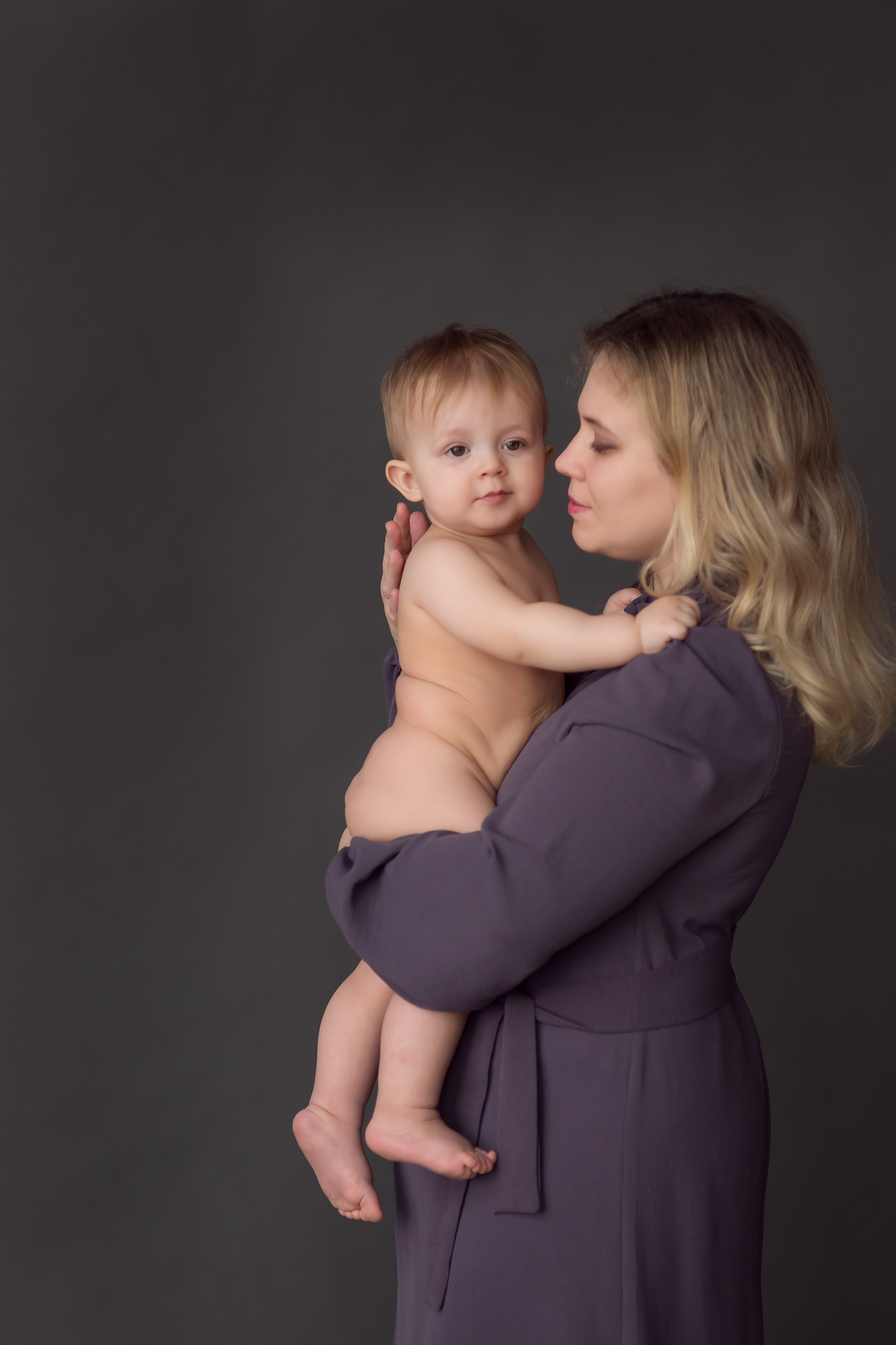 портрет обаятельного малыша у мамы на руках