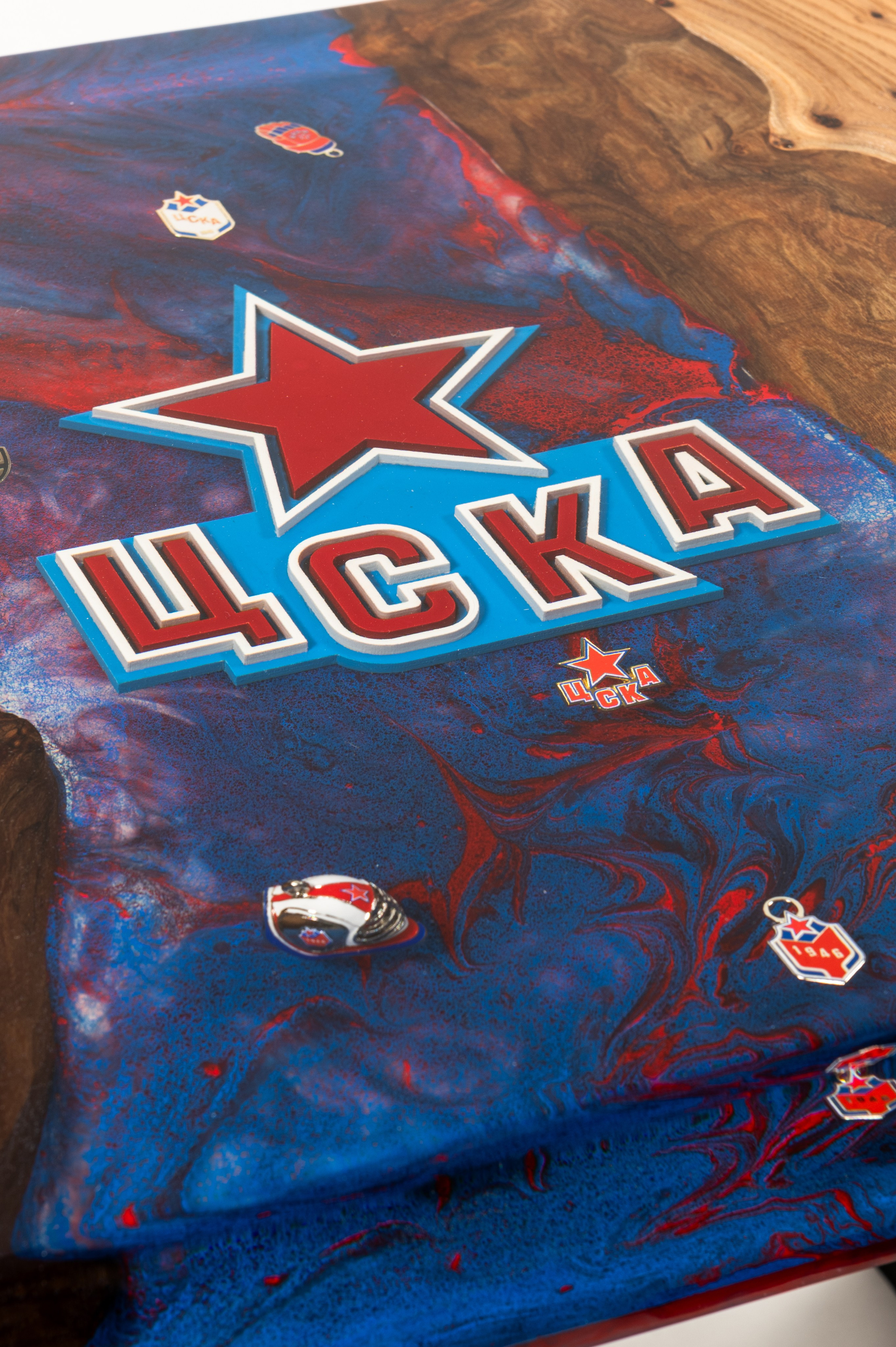 Крупный план деревянной столешницы с красно-синей эпоксидной вставкой и логотипом хоккейного клуба "ЦСКА"