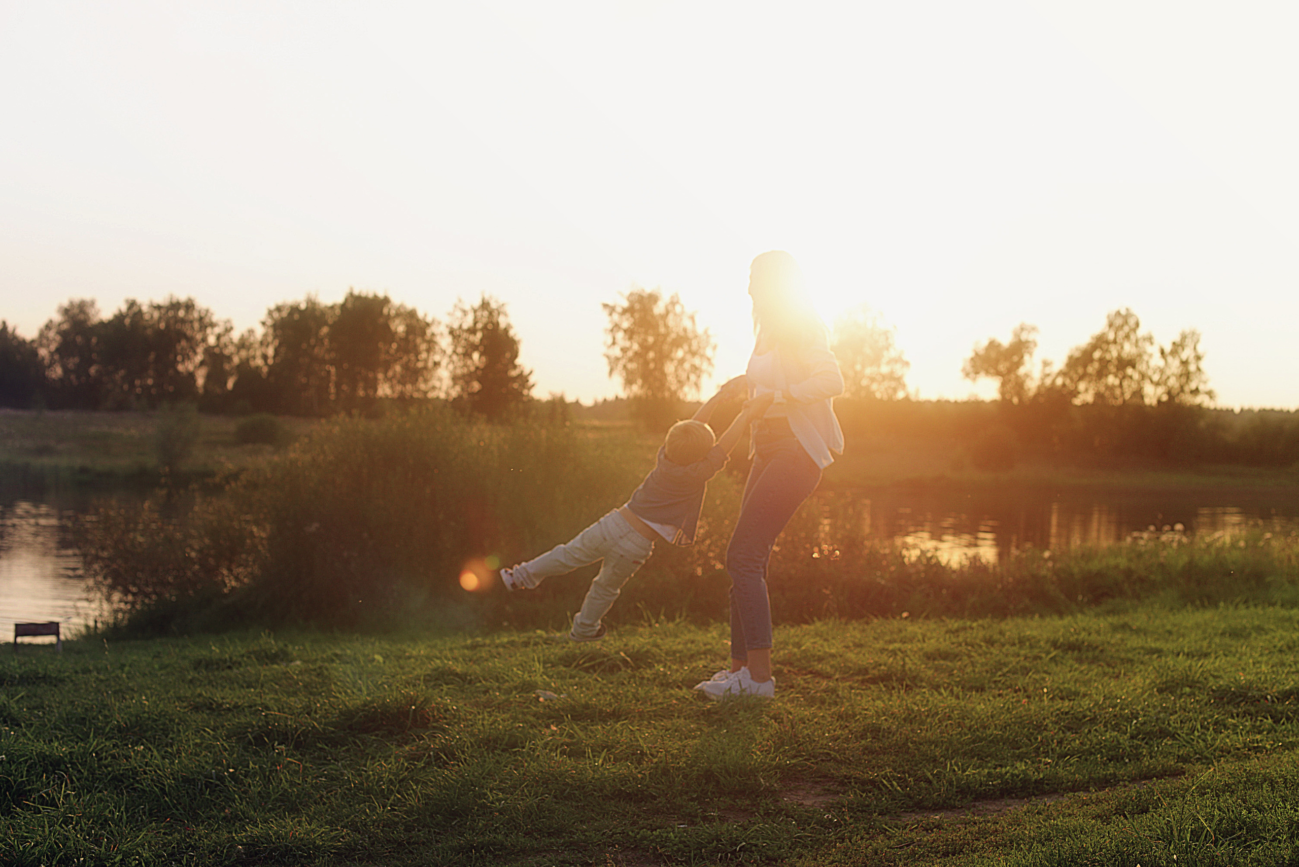 мама и сын летом на закате у озера 