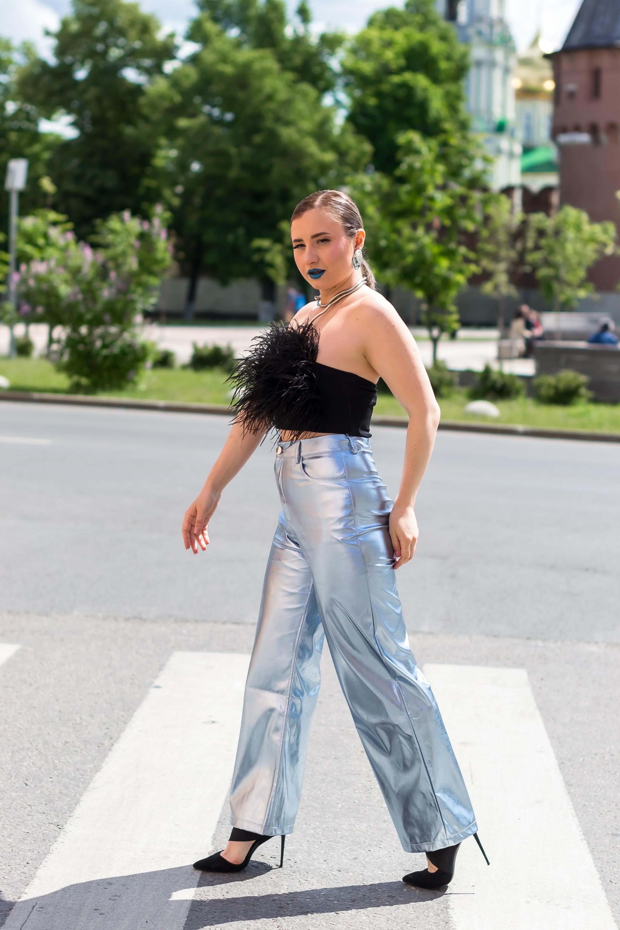 На фотографии девушка идет по улице через пешеходный переход.