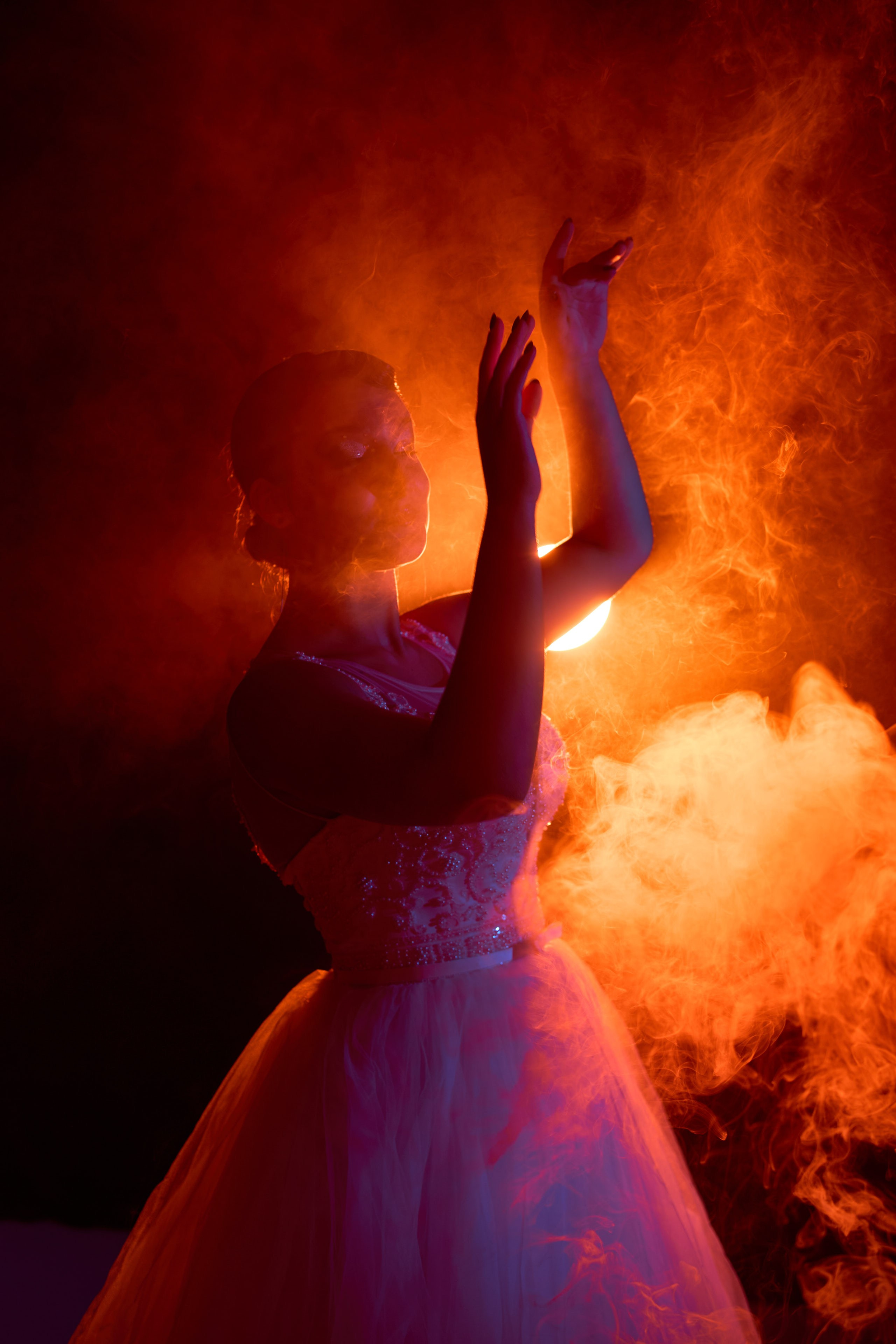 Девушка в образе невесты окутана дымом, подсвечена контровым оранжевым светом