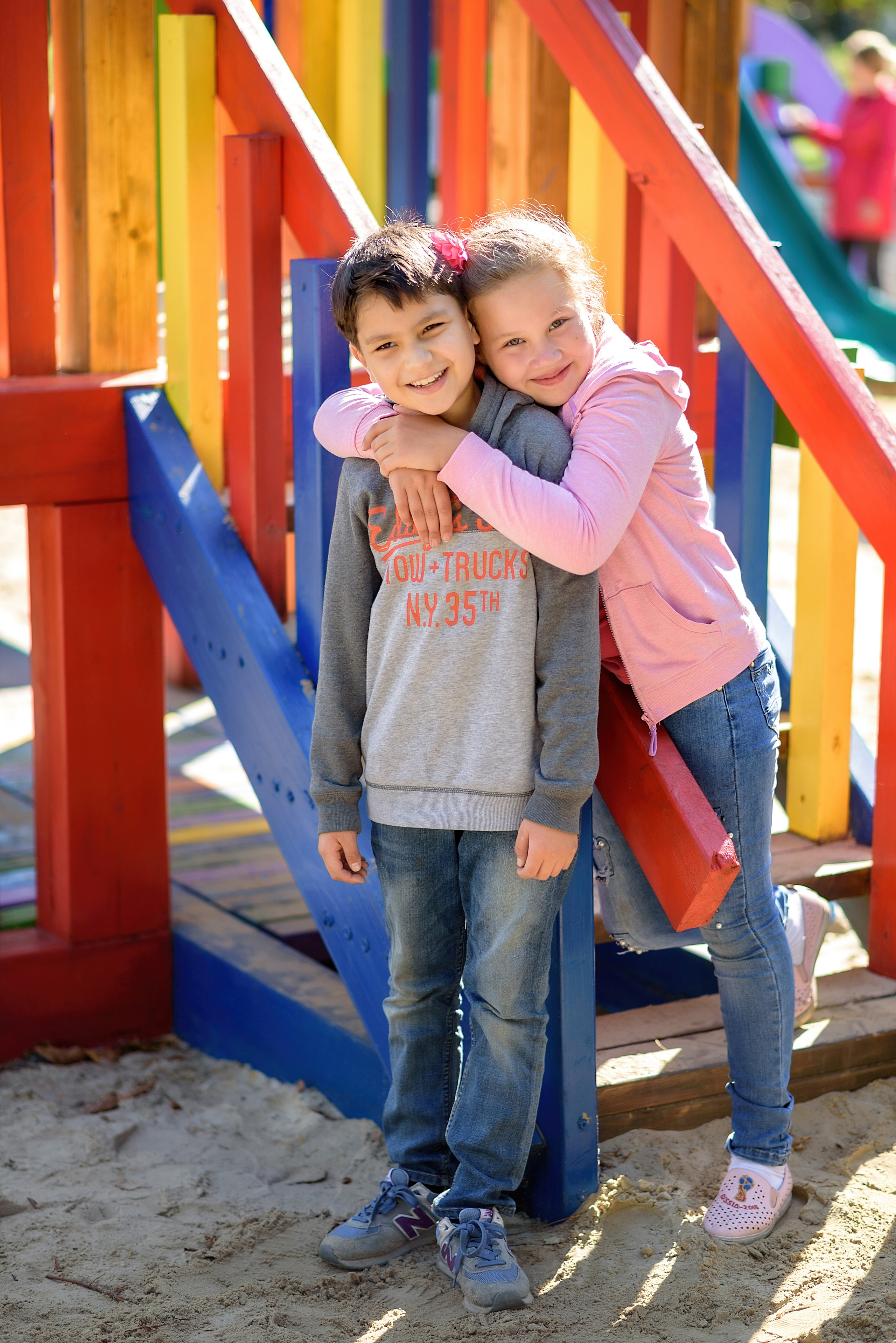 Фотография двух школьных друзей на детской площадке в городском парке