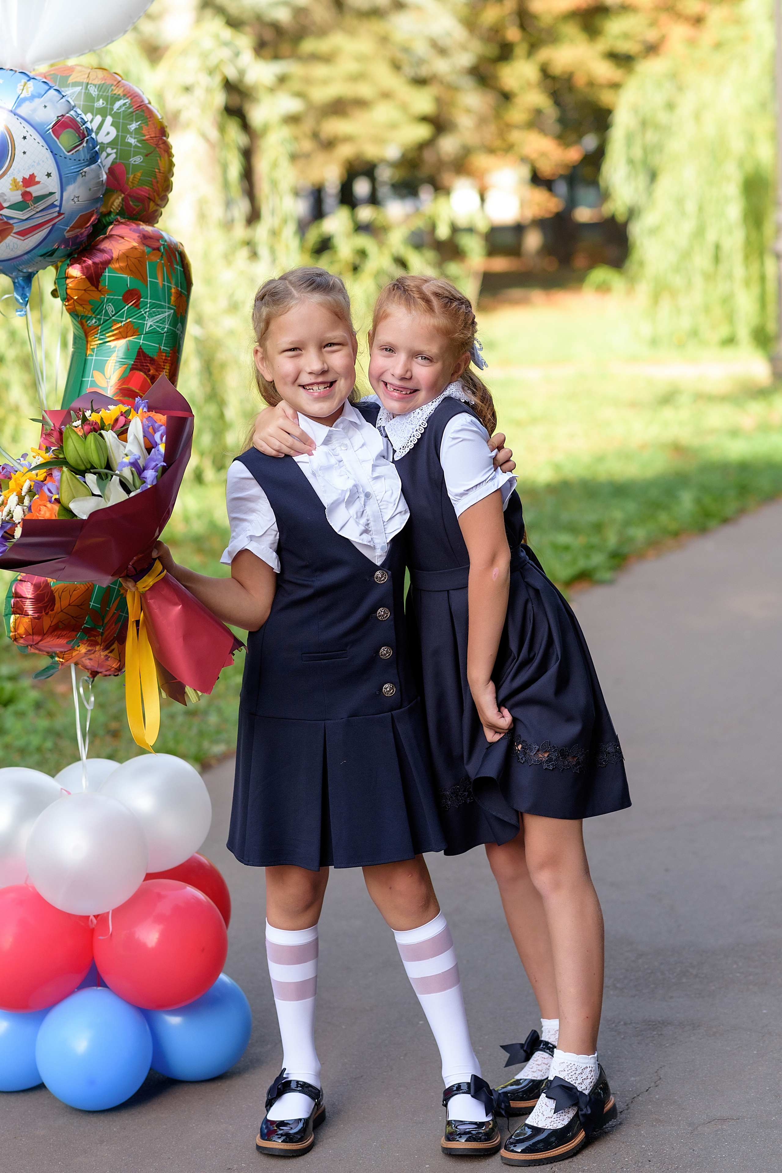 Фотография двух школьниц на первое сентября в школьной форме и с шариками