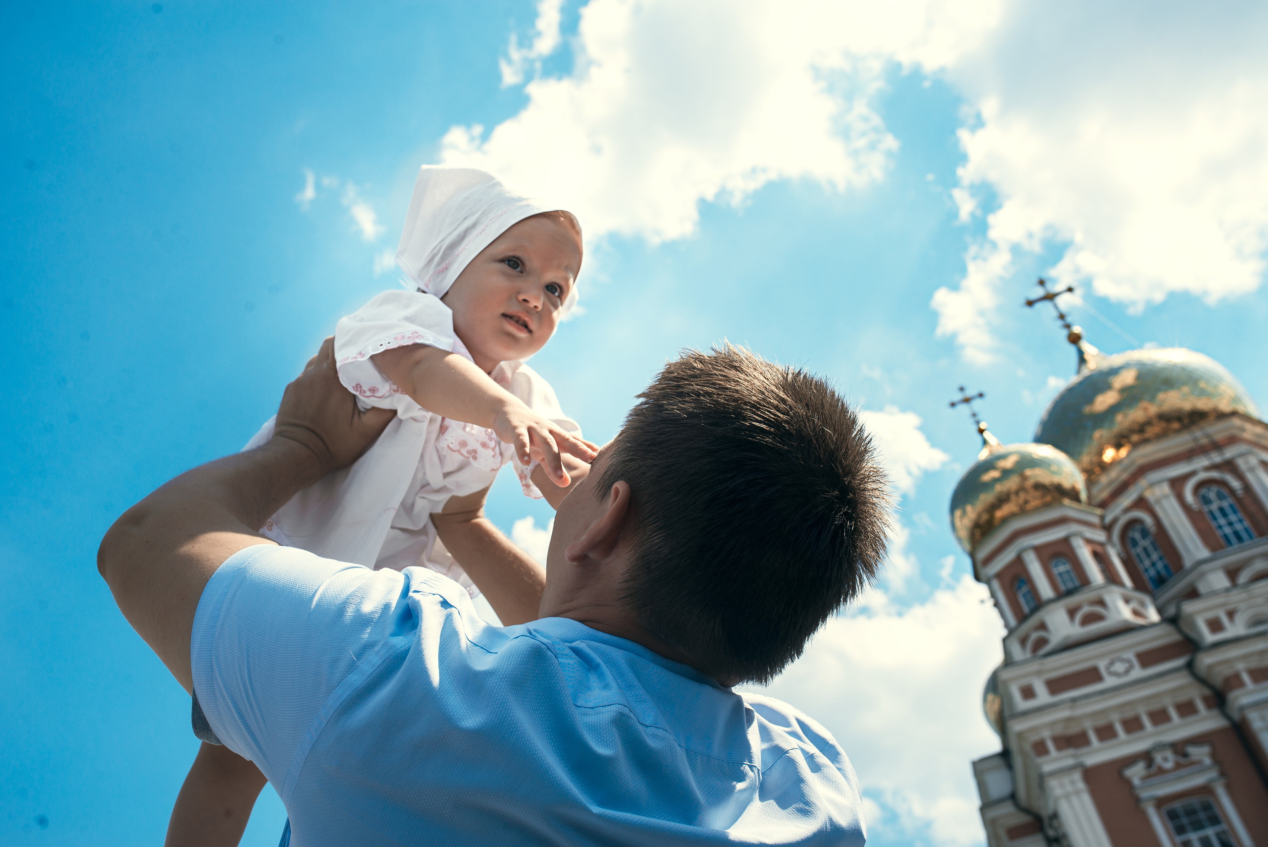 ребенок у папы на руках на фоне храма в саратвое покровский храм