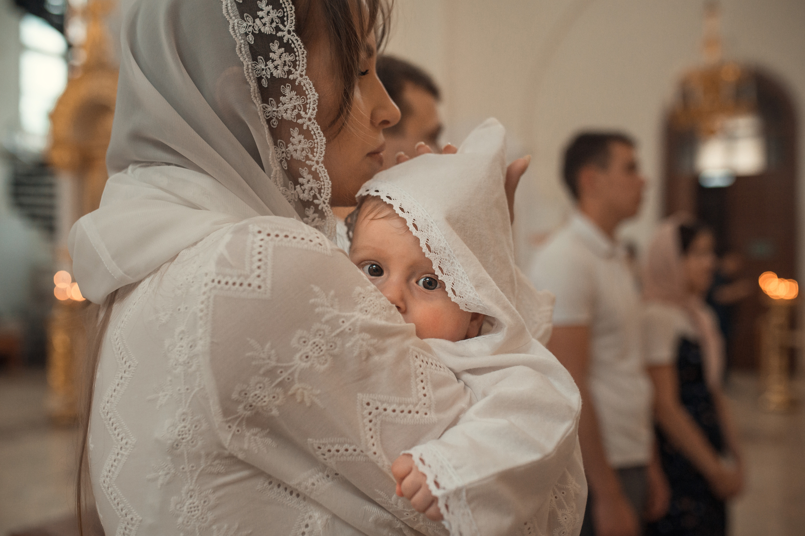 малыш полдсматривает из за маминого плечпа