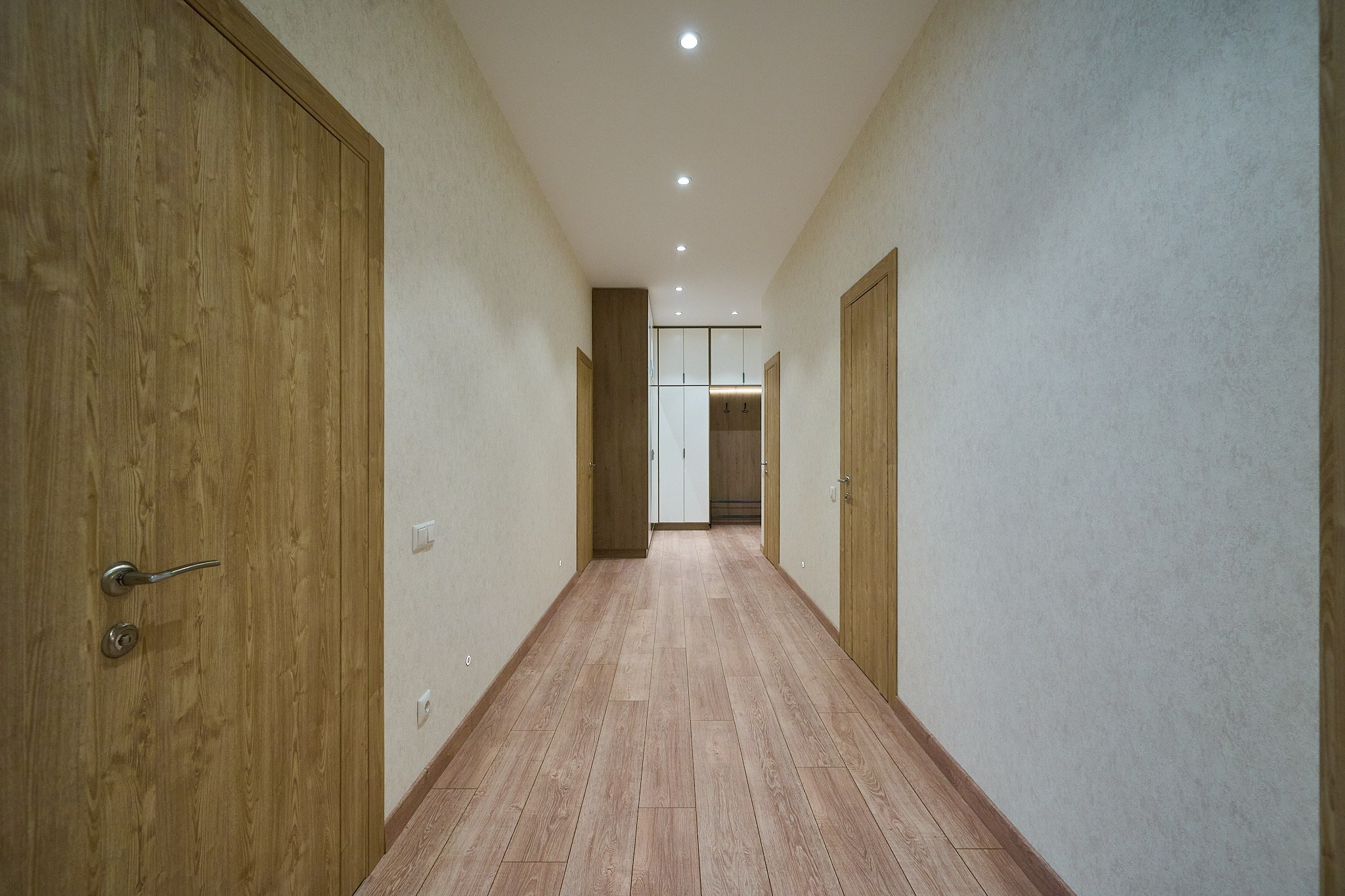 коридор с деревянными дверями и белыми стенами 