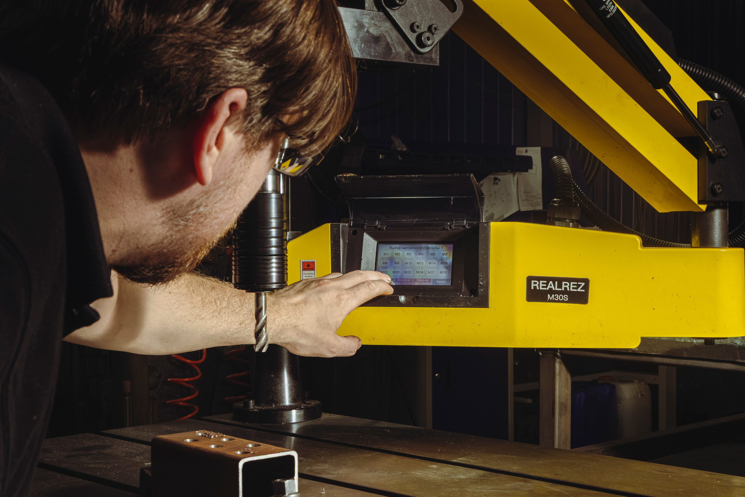 Инженер у станка: настройка промышленного оборудования для производства вакуумных захватов.