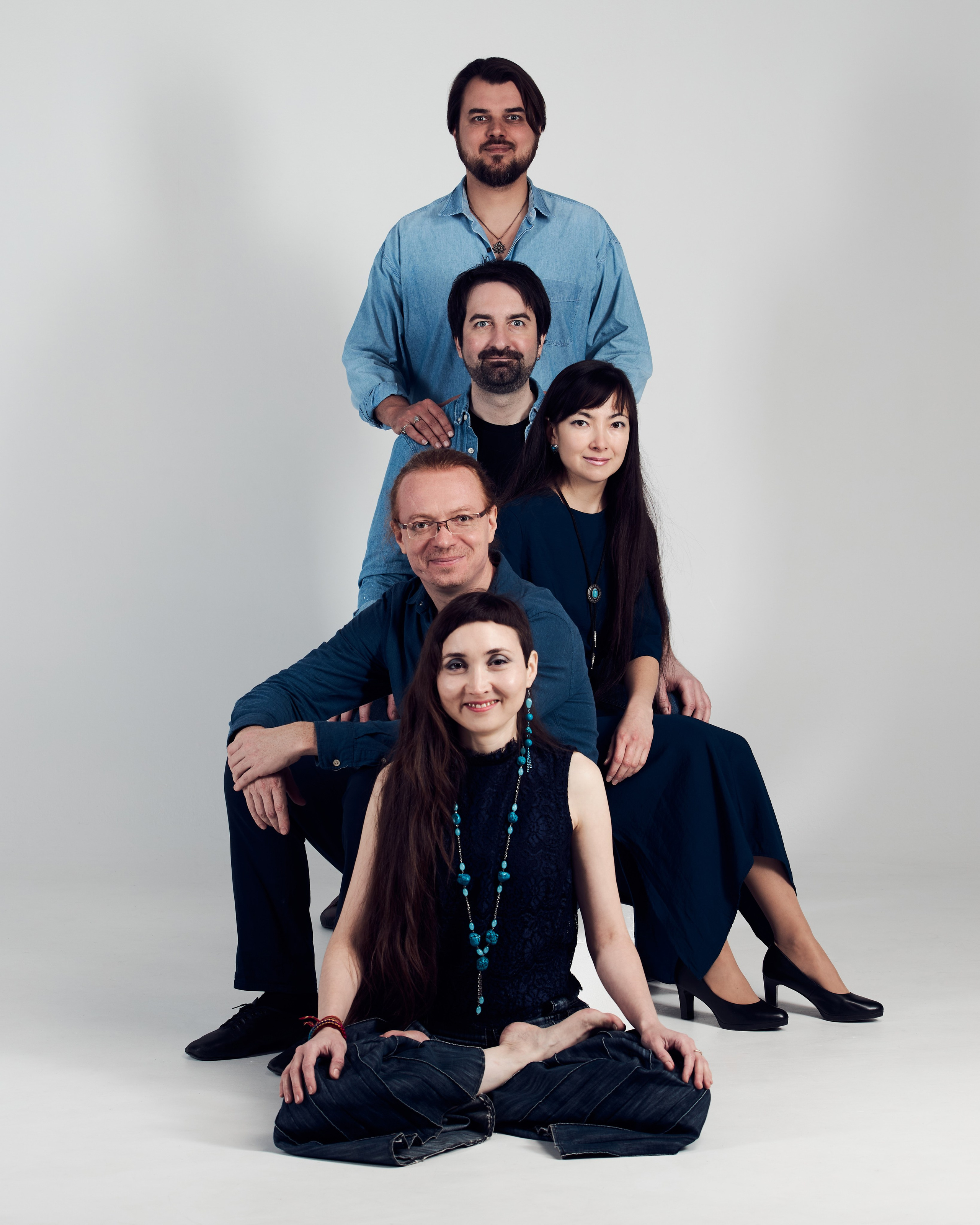 Групповое фото пяти человек, расположившихся один за другим в ряд "ёлочкой" на белой циклораме