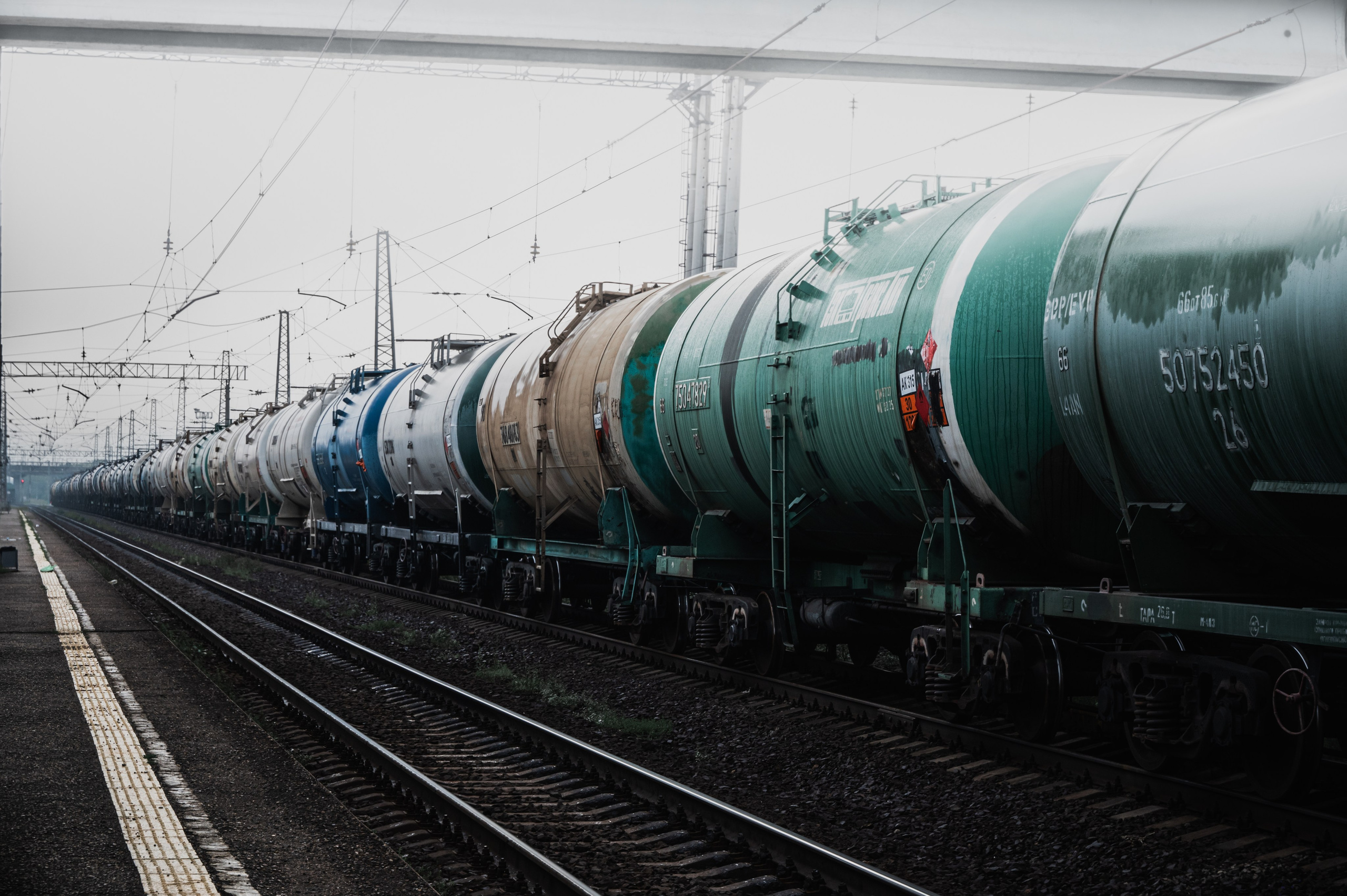 Железнодорожные пути и вагоны цистерны на фоне тумана