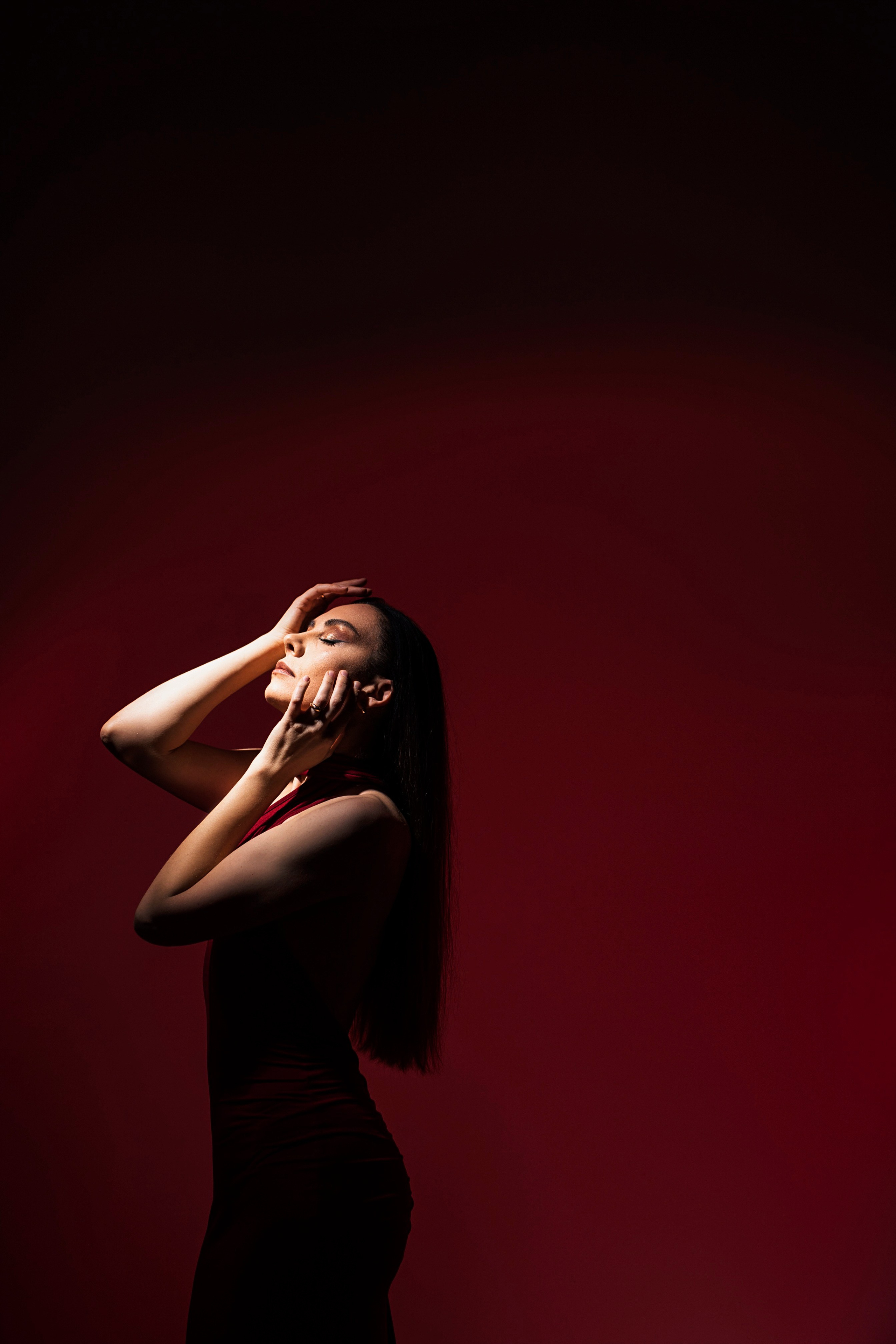 Студийная фотосессия девушки на красном фоне