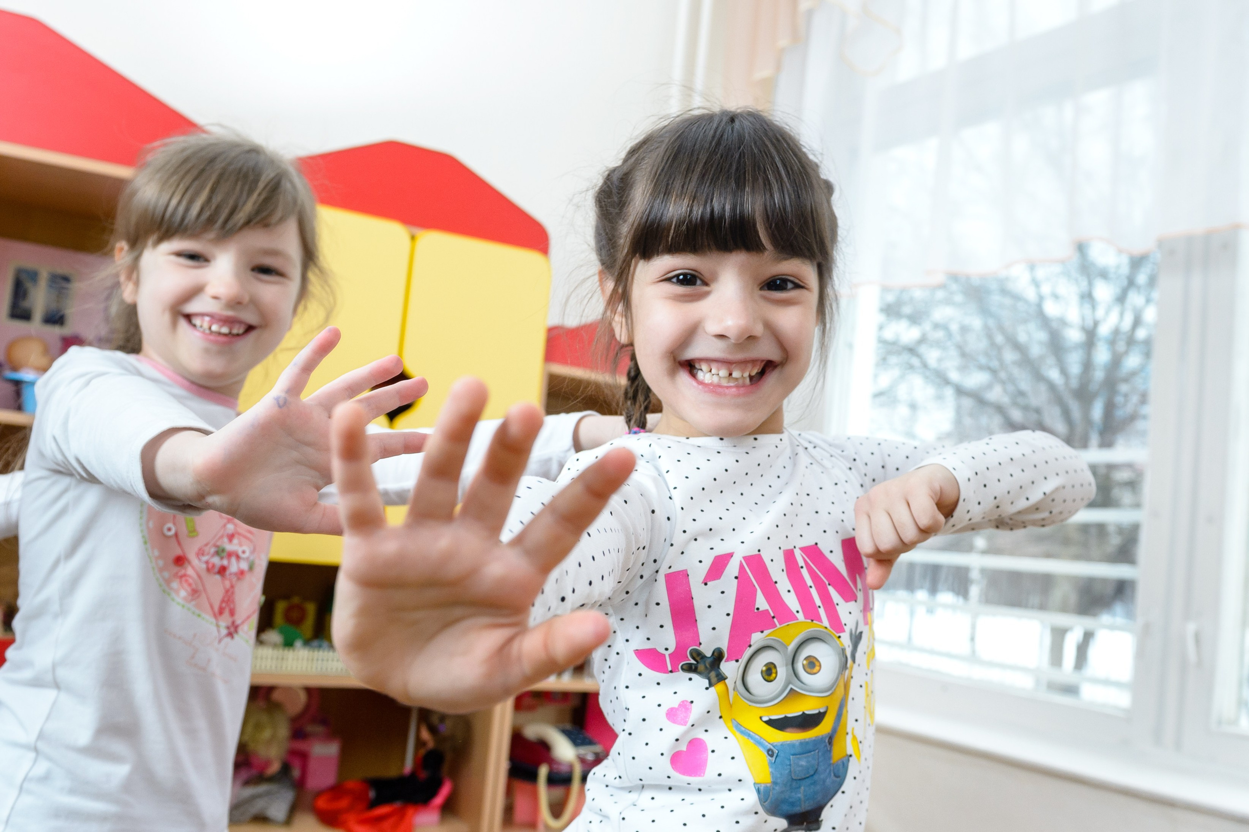 Две девочки танцуют в детском саду. 