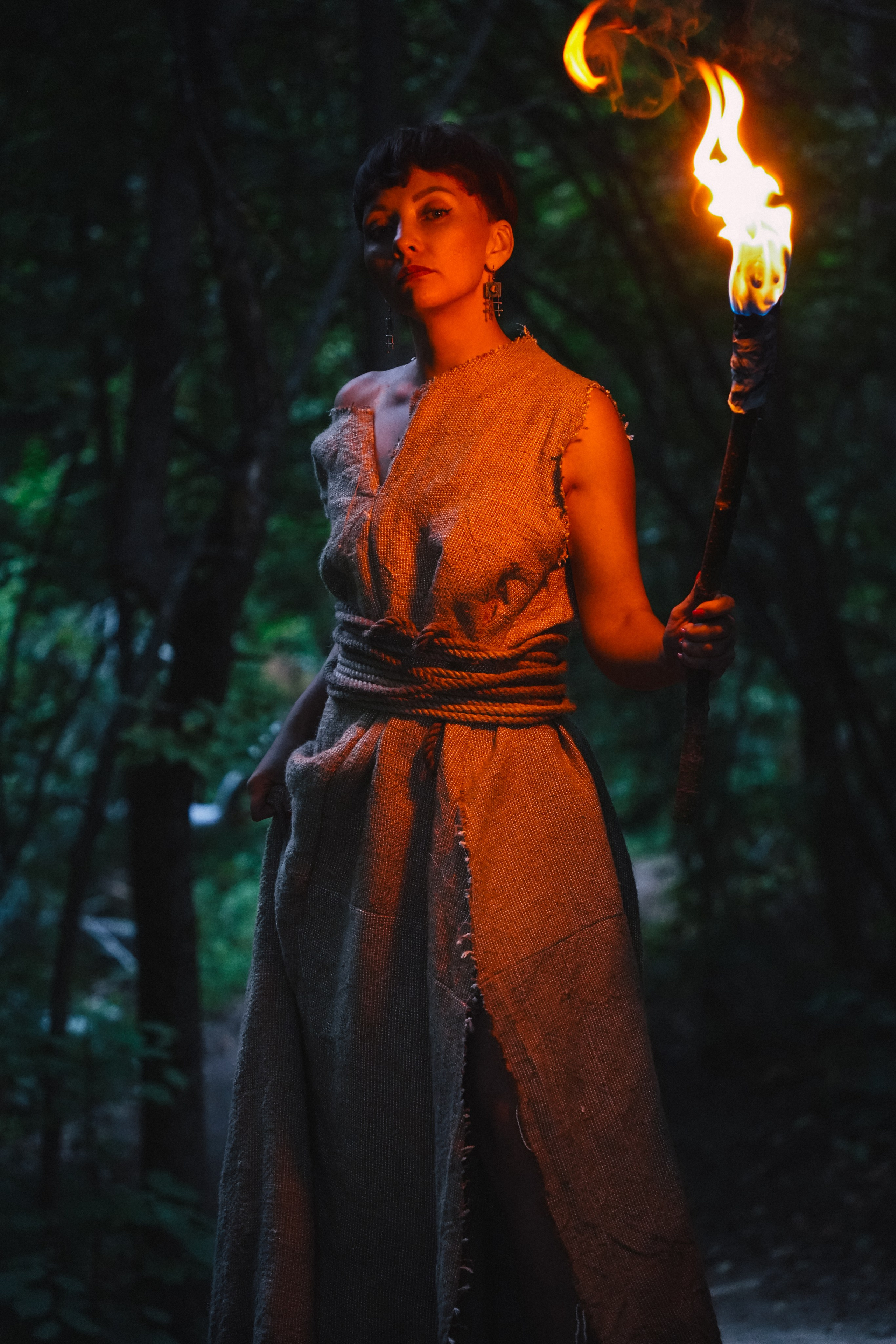 Девушка в лесу с факелом в руке