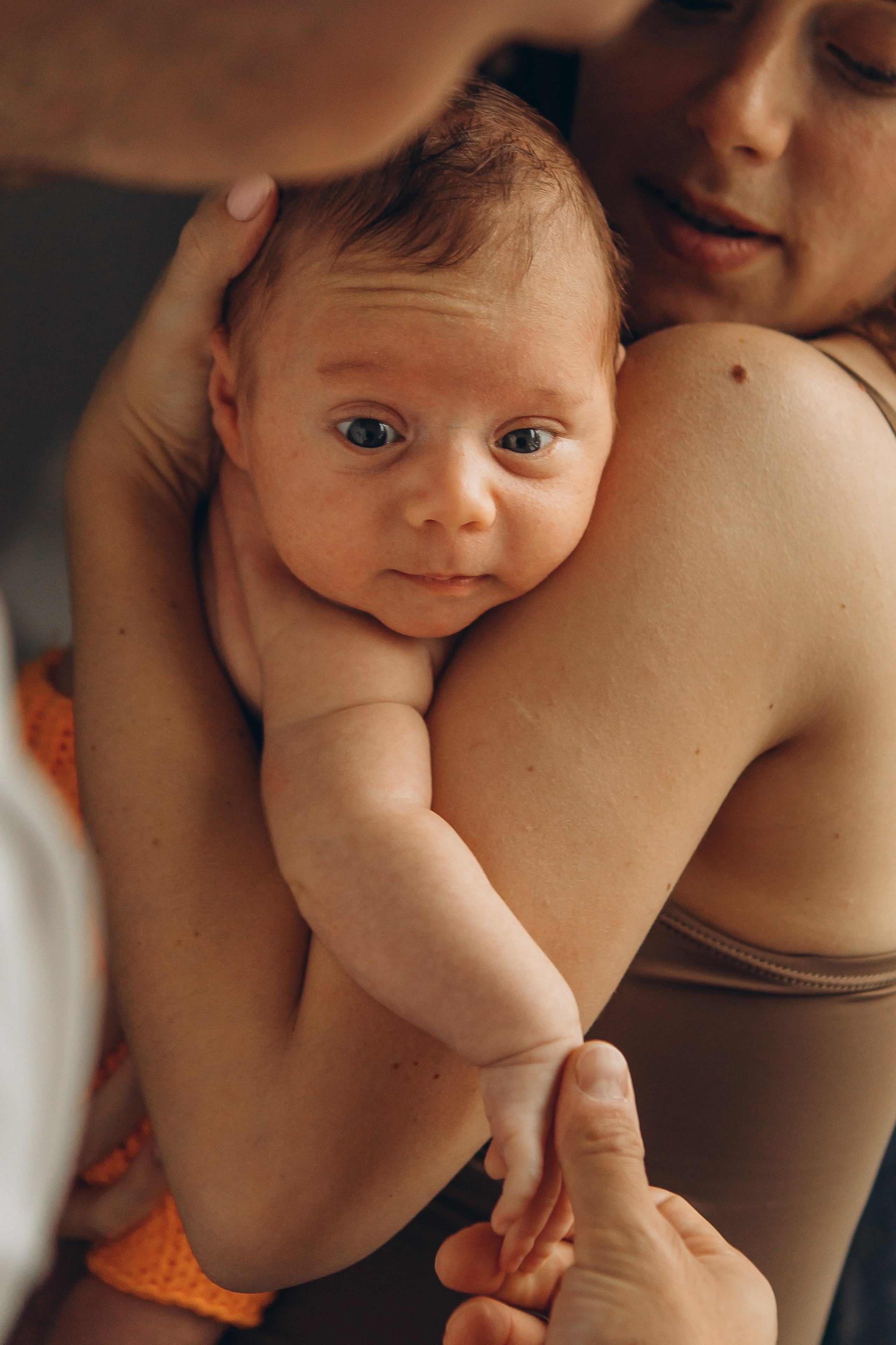 Мама бережно придерживает голову новорождённого на руках. Семейная фотосессия в Санкт-Петербурге. Первые фотографии новорождённых для семейного альбома, фотограф Маруся Самылкина в спб.