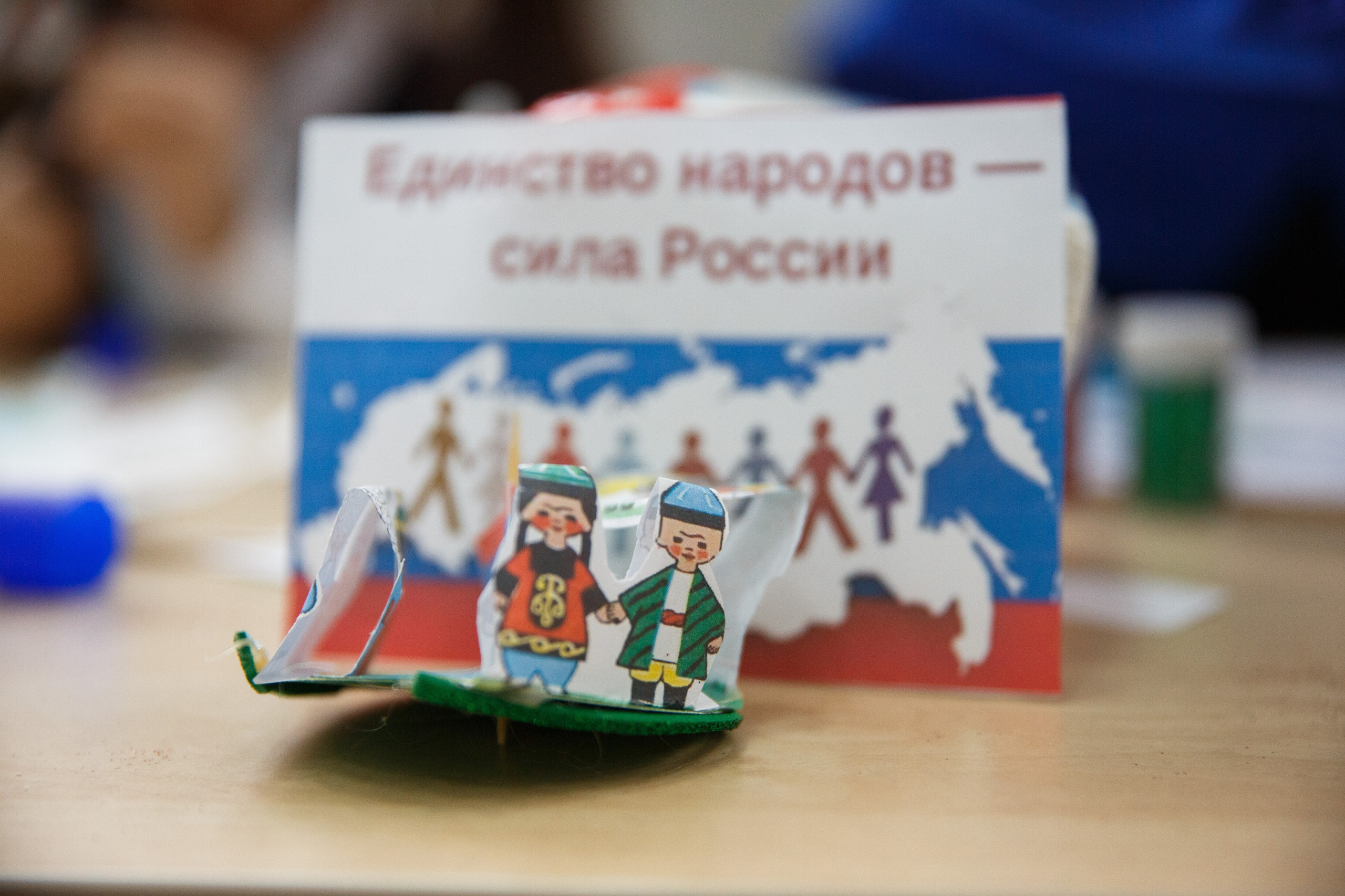 Бумажная поделка и надпись “Единство народов – сила России”.