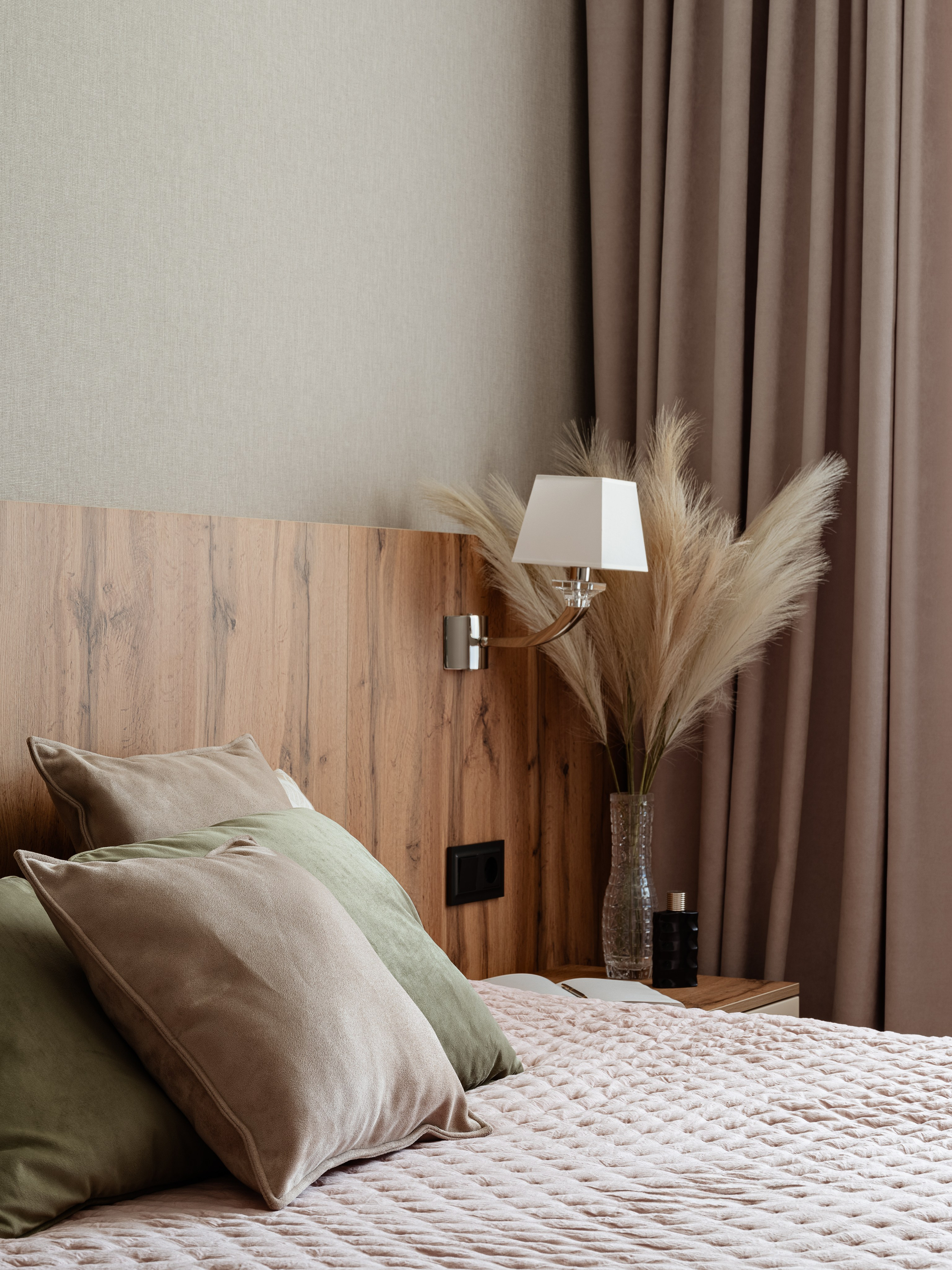 Интерьер спальни в мягких пастельных оттенках, изголовье под дерево, подушки в зелёных и бежевых тонах, декоративная ваза с сухоцветами, спокойный уютный стиль, дизайнер Алина Чередниченко, фотограф Сергей Денисенко