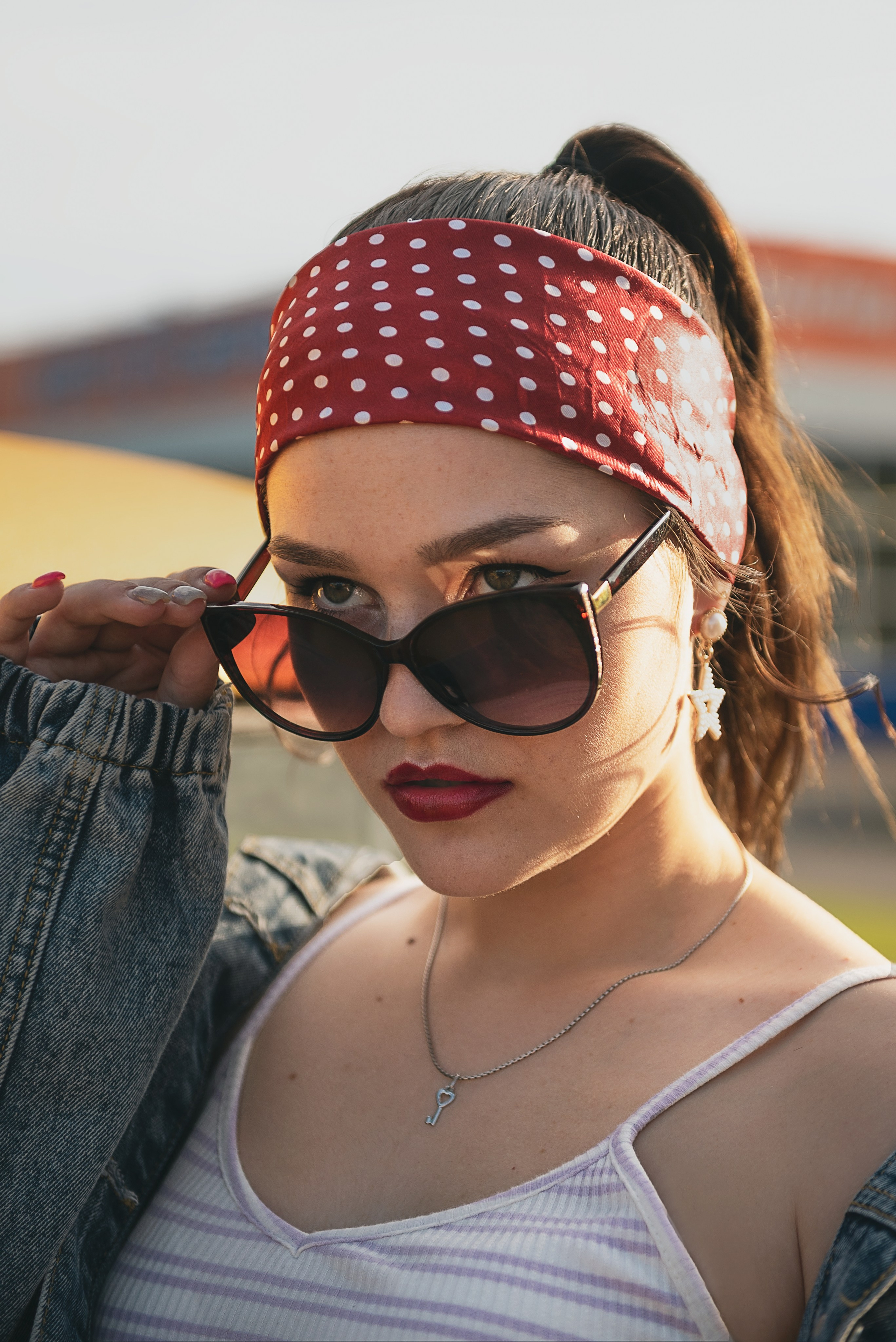 Стильный портрет девушки в солнцезащитных очках на улице в летний день.