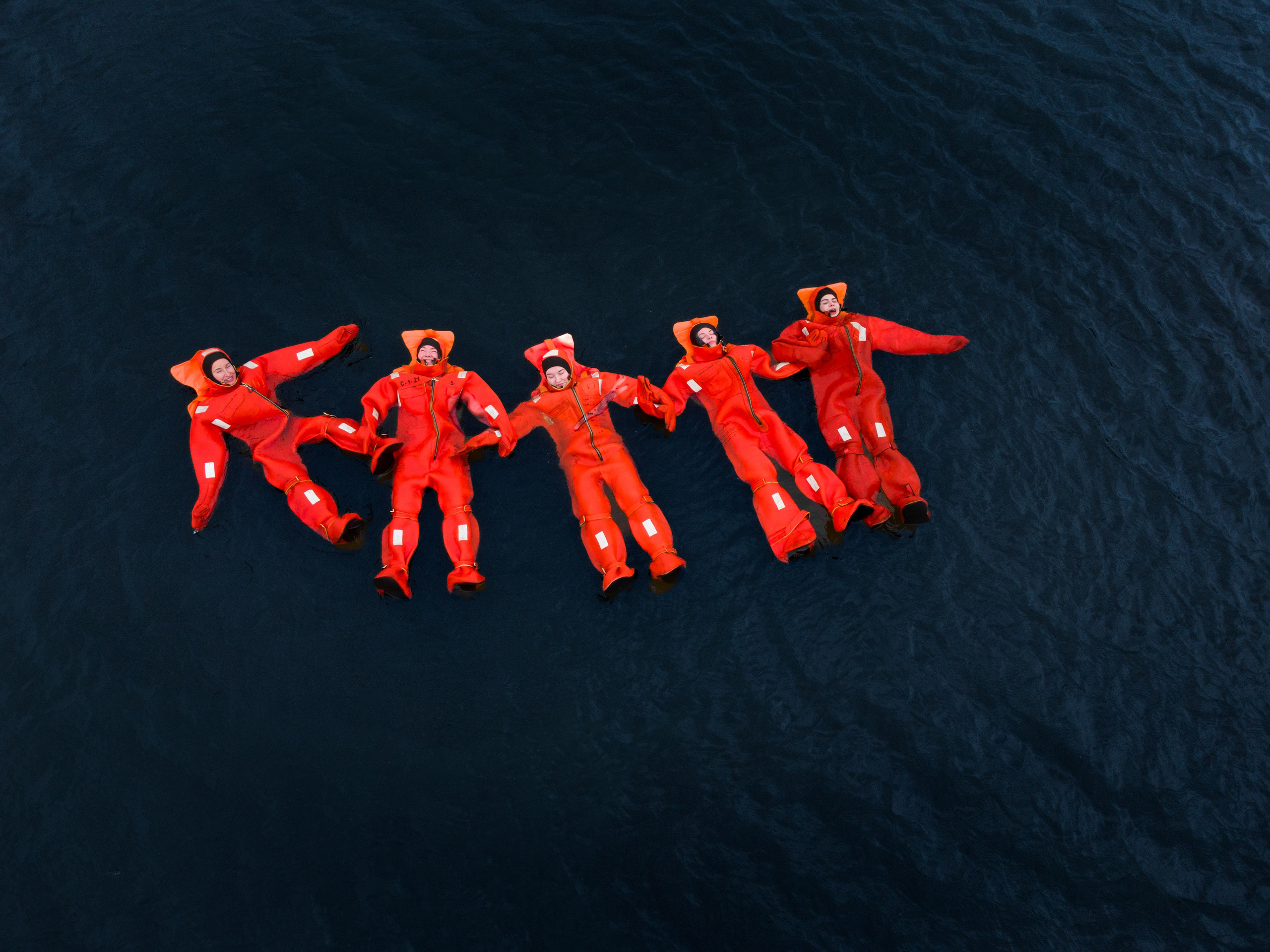 Люди купаются среди льдин, в спасательных оранжевых термо костюмах, айс флоатинг Ярославль