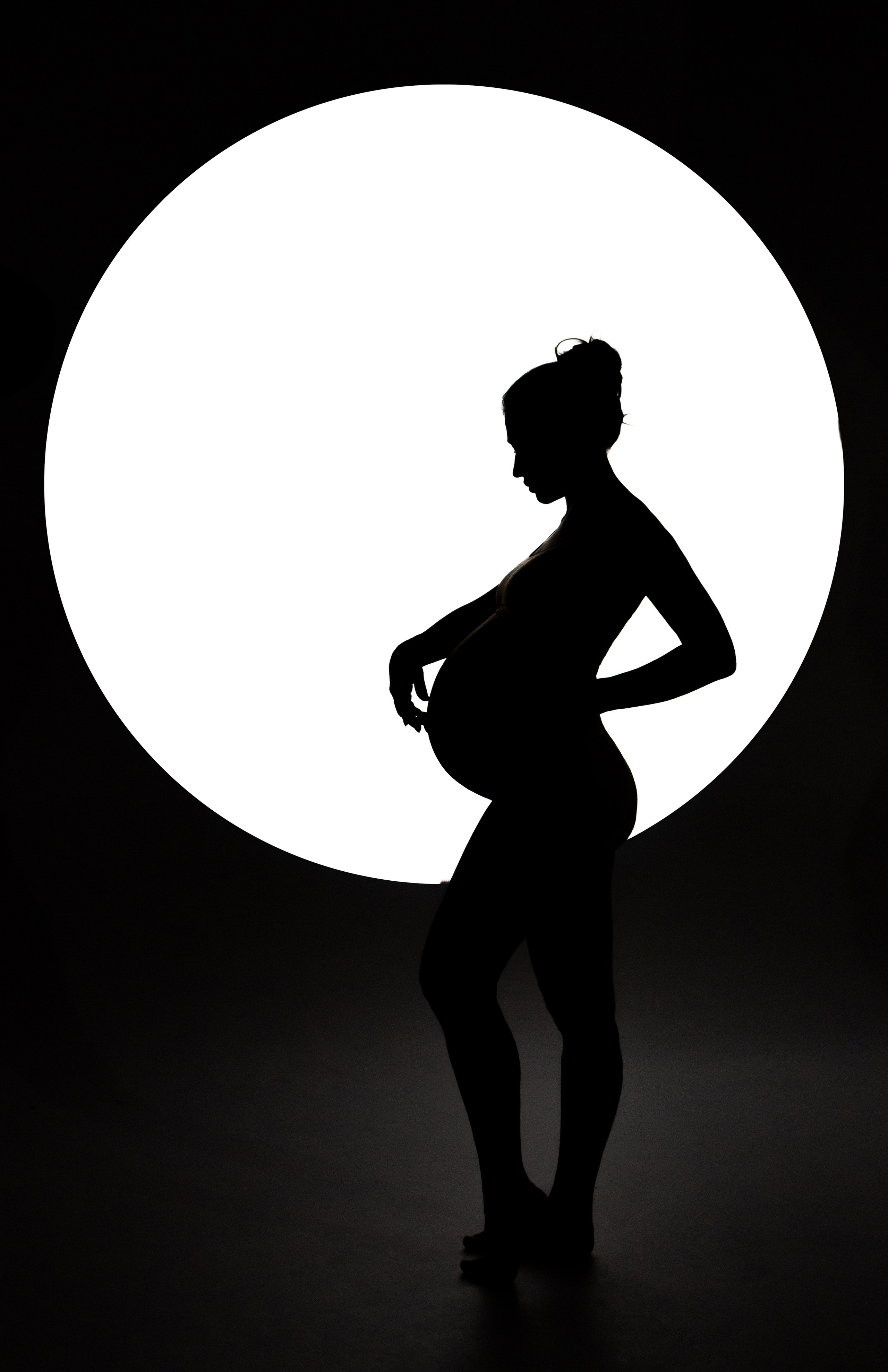 силуэт беременной девушки в белом круге