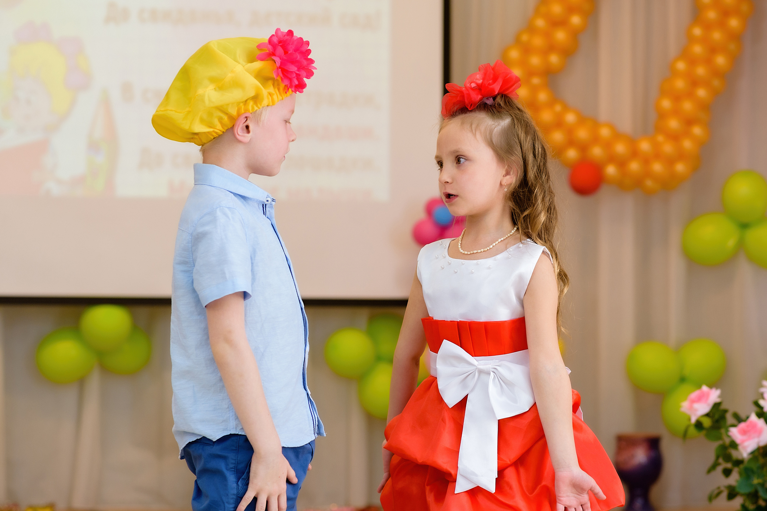 Девочка и мальчик показывают сценку на выпускном из детского сада