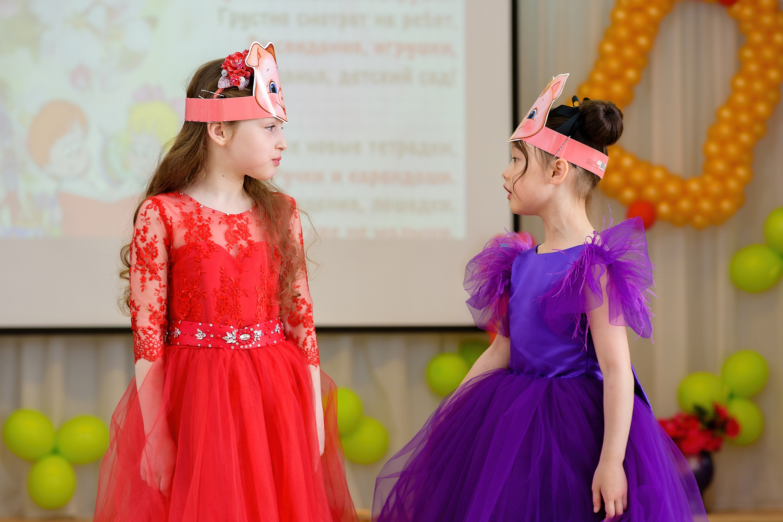 Две девочки на выпускном утреннике показывают сценку