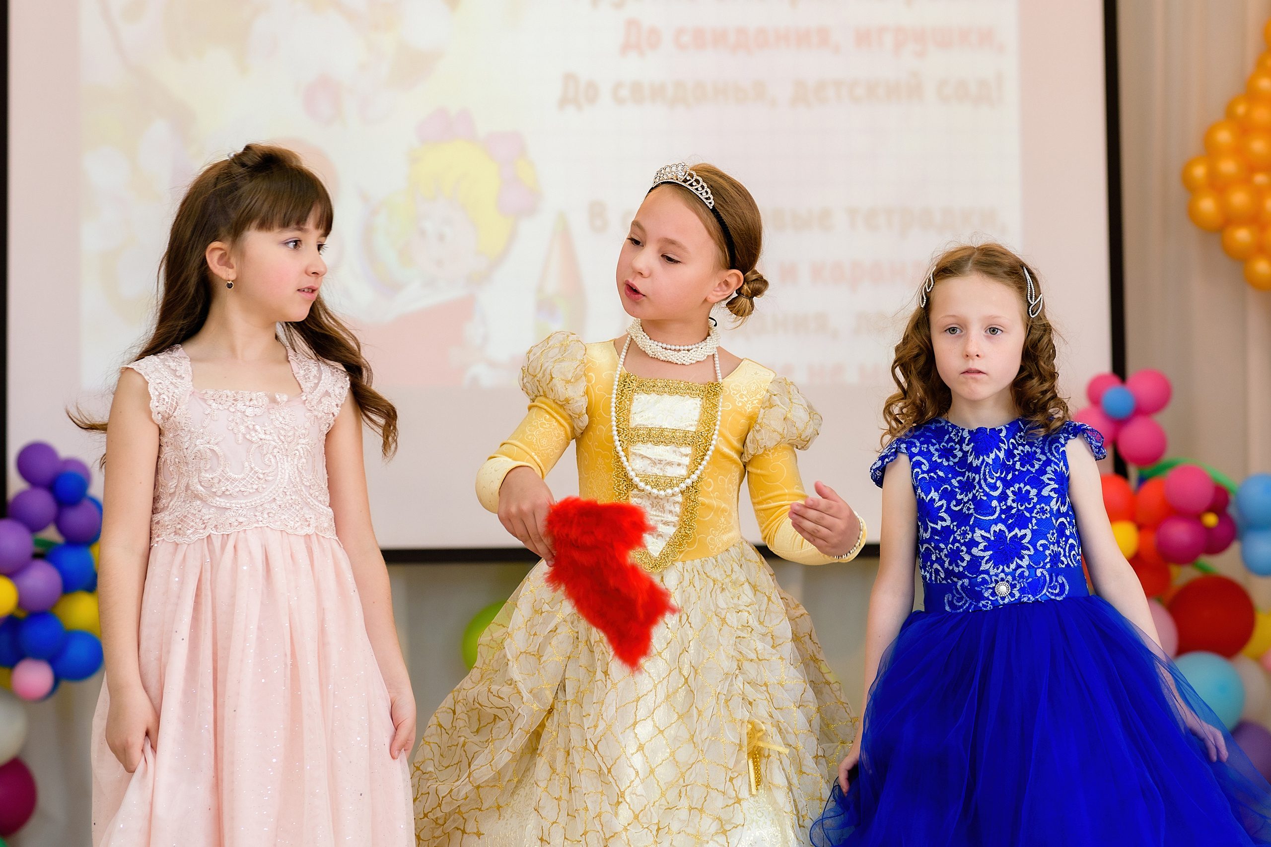 Три девочки показывают сценку из сказки Золушка на выпускном из детского сада