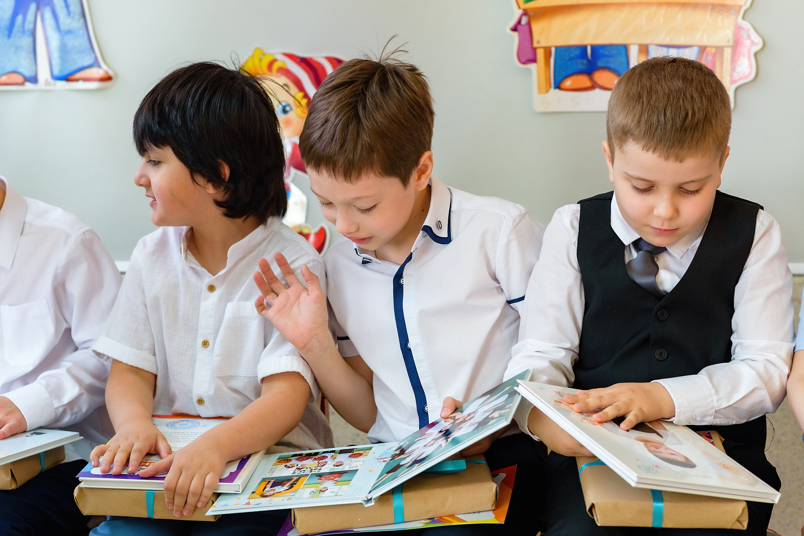 Дети получили в подарок выпускные альбомы и рассматривают их