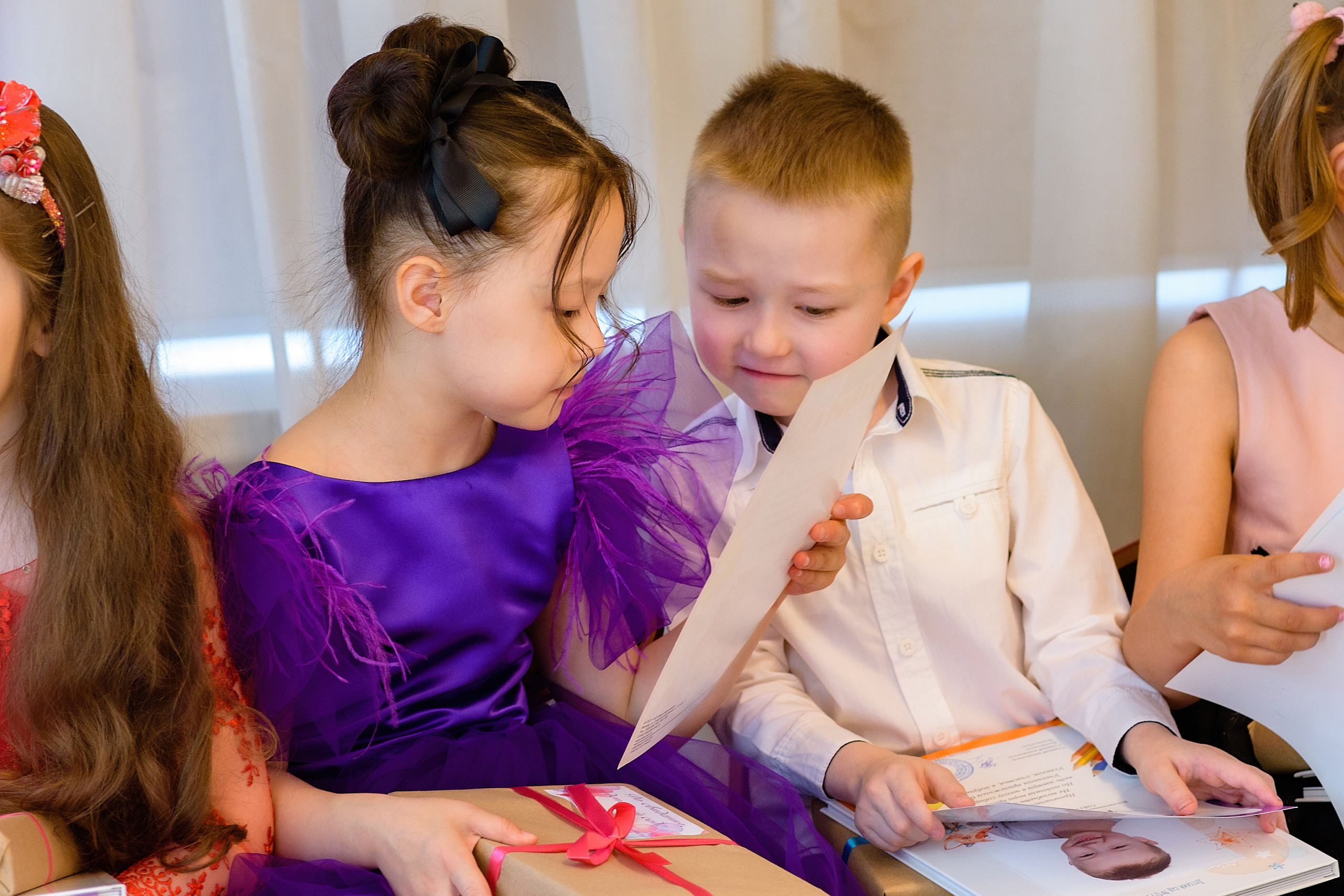 Девочка рассматривает грамоту на выпускном из детского сада