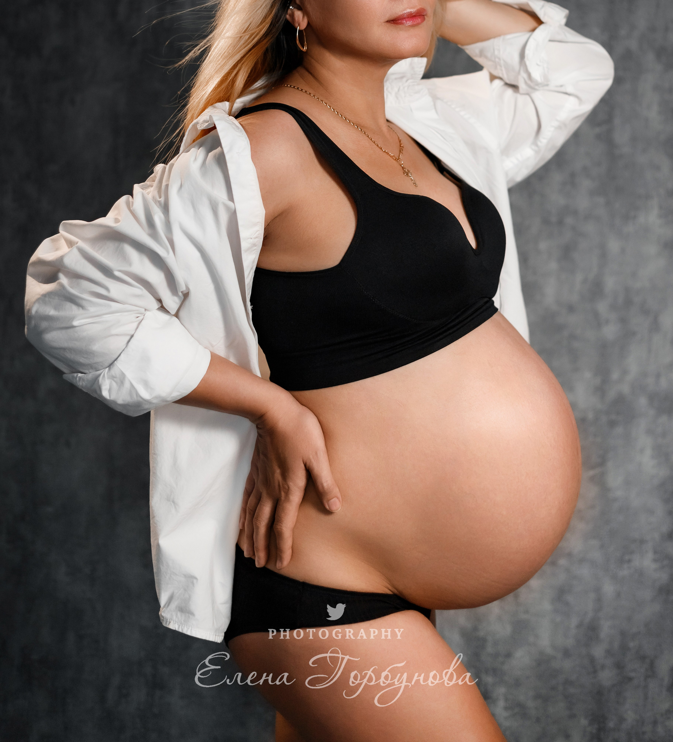 беременная девушка позирует в белой рубашке под вентилятором