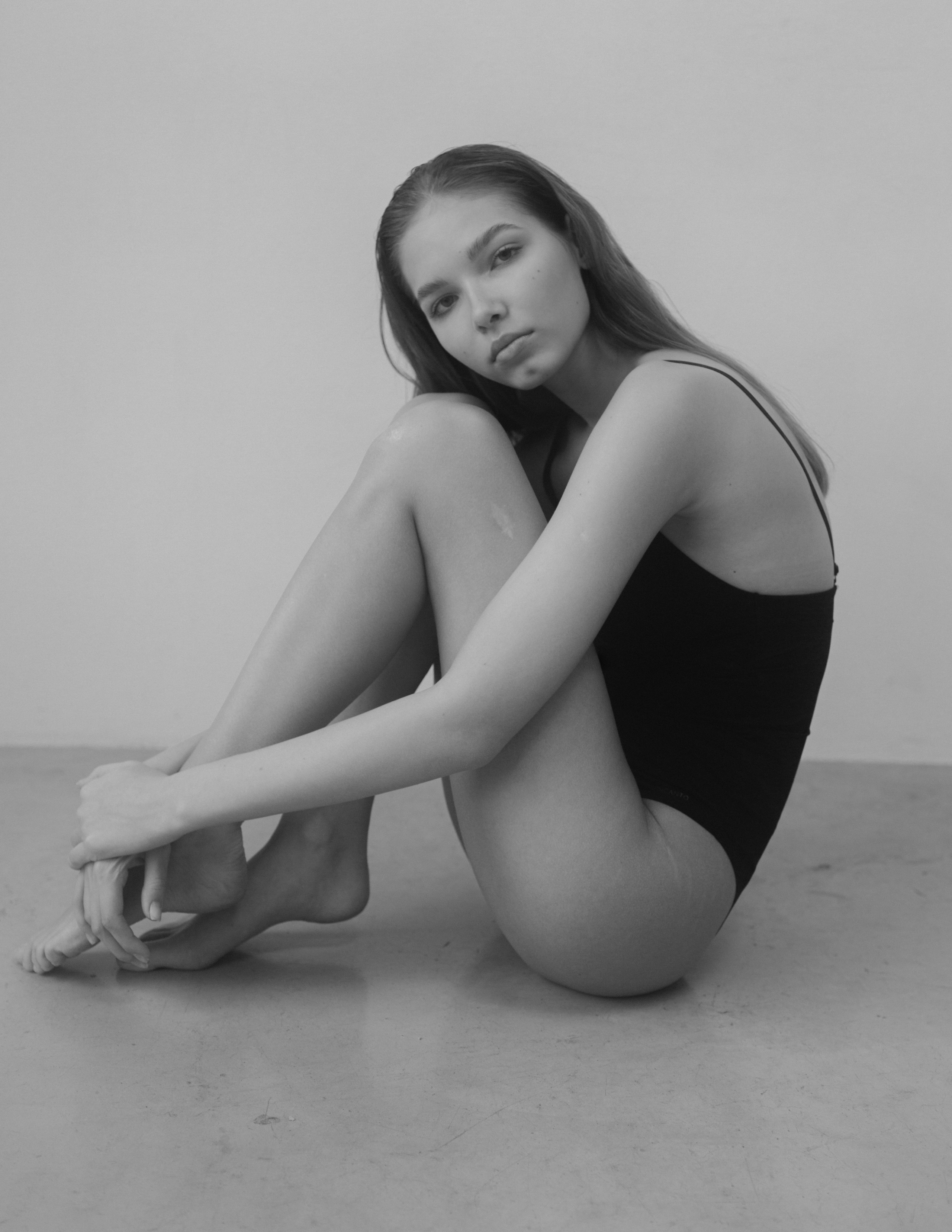 Модель в боди сидит на полу