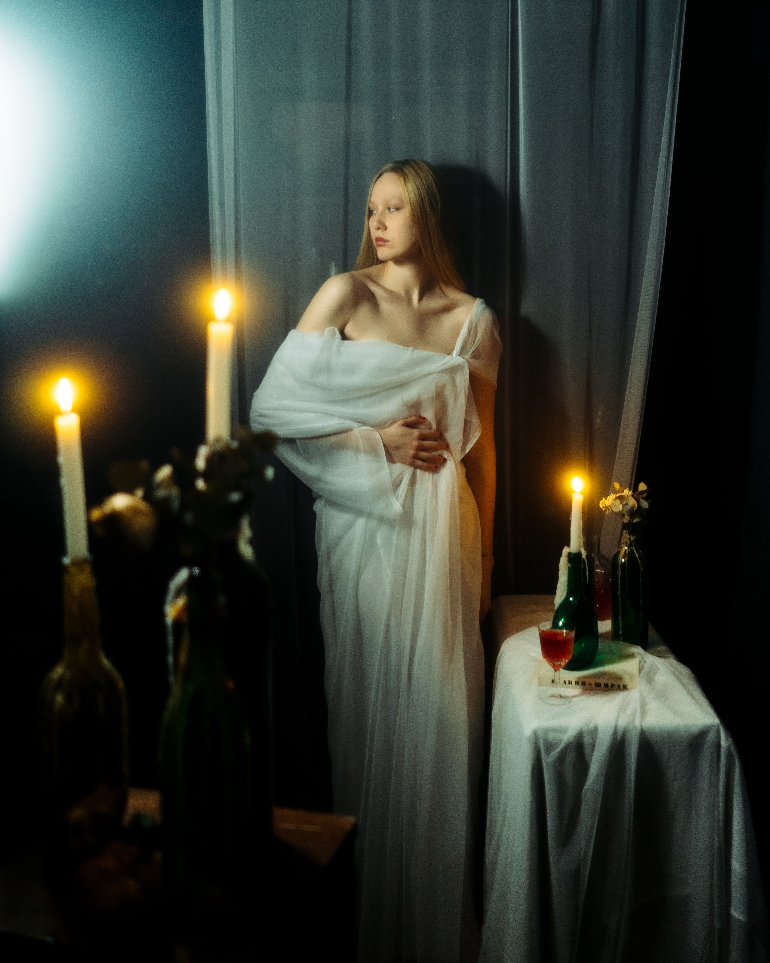 Авторская фотосессия девушки в полный рост, белая драпировка, свечи и темный интерьер, атмосферная женская съемка в фотостудии СПб в винтажном стиле