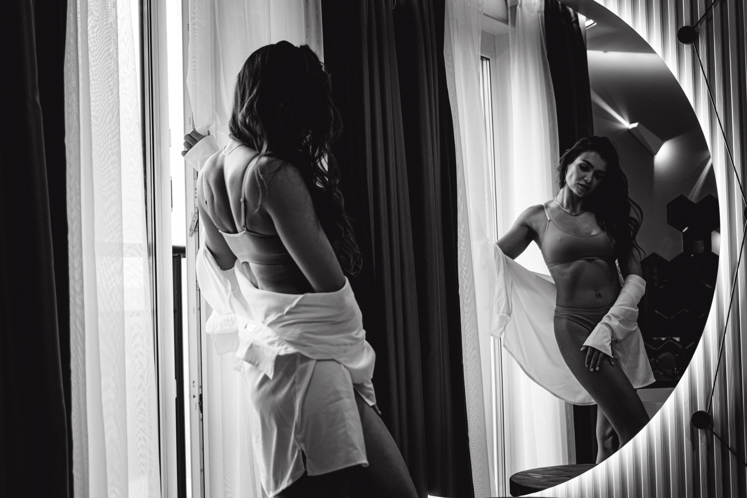 "На фото запечатлено чарующее присутствие девушки, которая воплощает шик и изысканность в своем превосходном белье и модной рубашке."