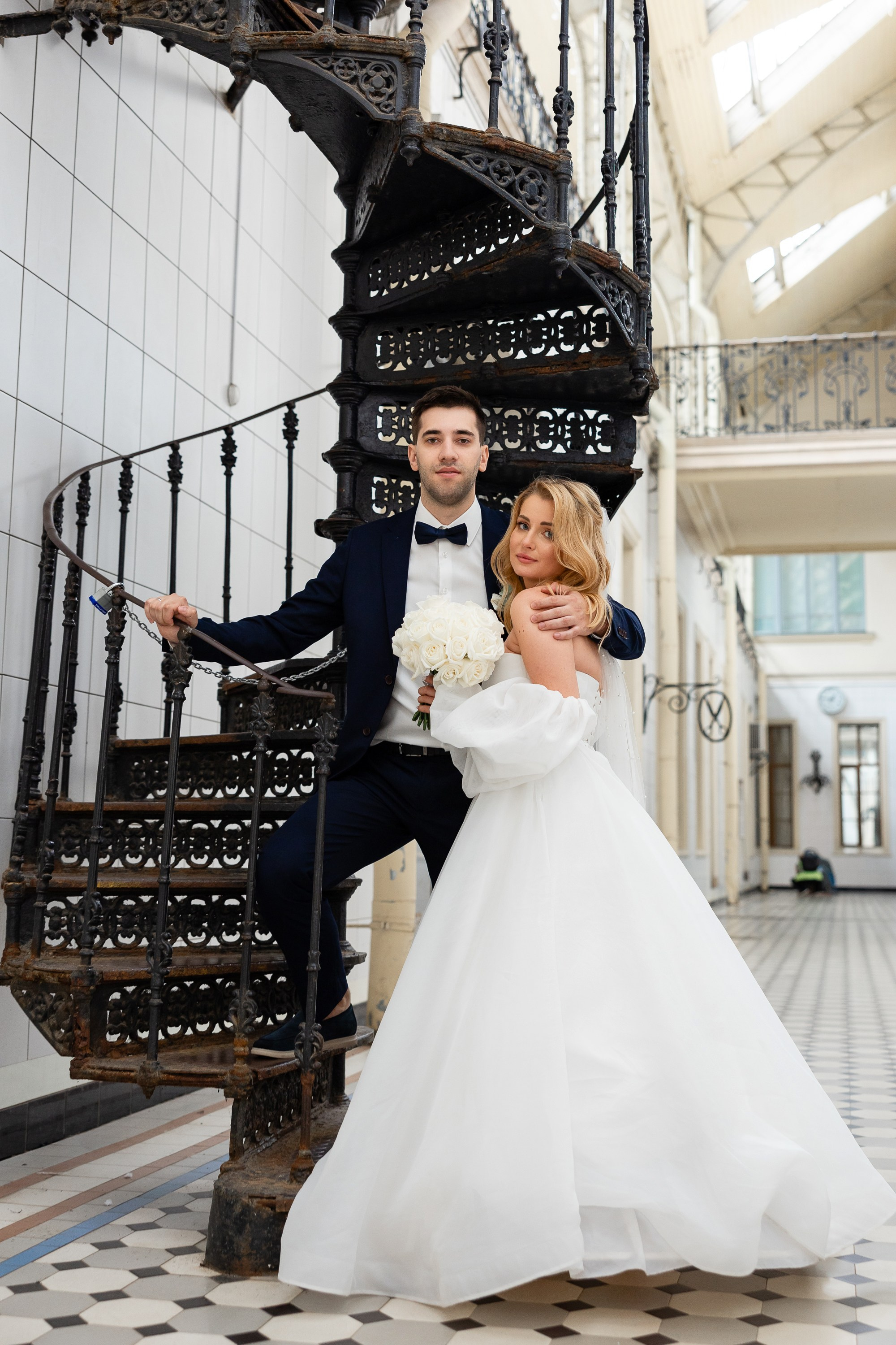 Жених и невеста фотографируются у винтовой лестнице Витебского вокзала
