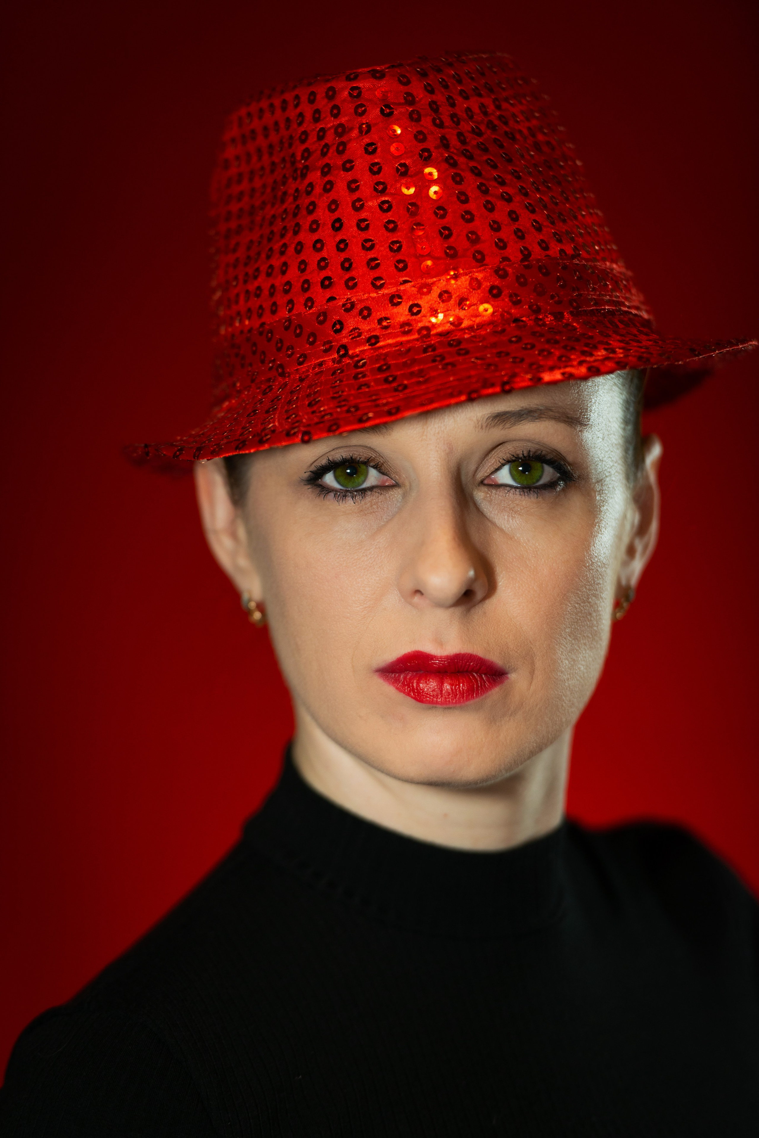 девушка  в красной шляпе на красном фоне с ярко красными губами портрет