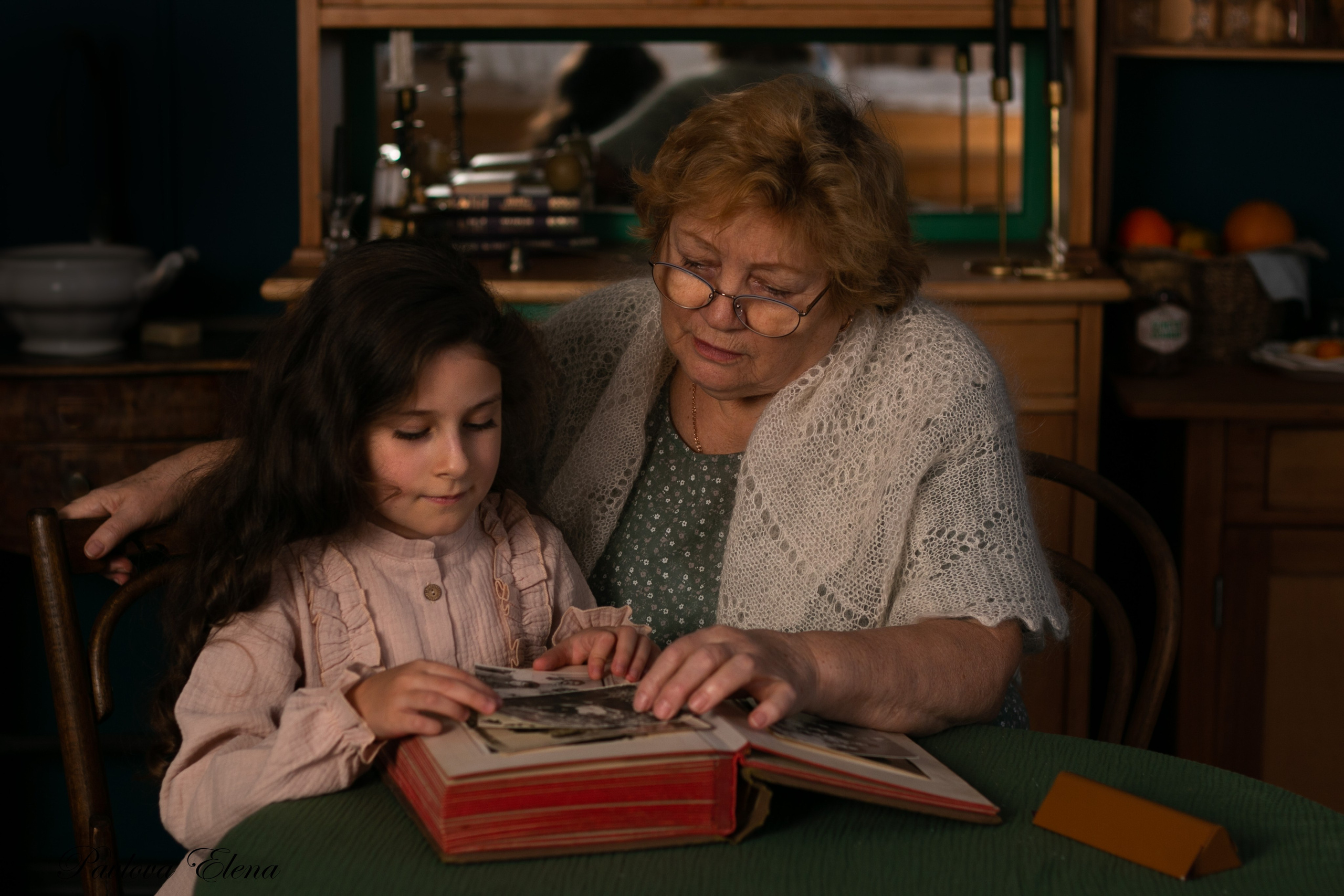 Бабушка и внучка уютно сидят на кухне, вспоминая прошлое