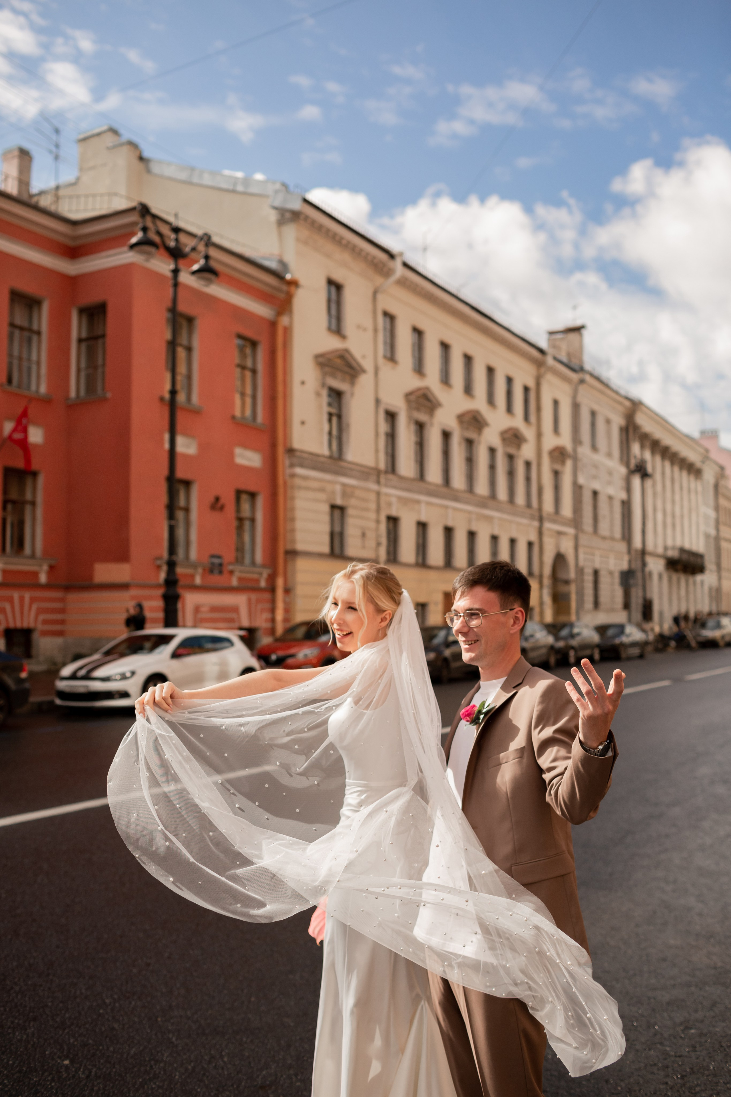 Невеста подкидывает фату на ветру в центре Петербурга.