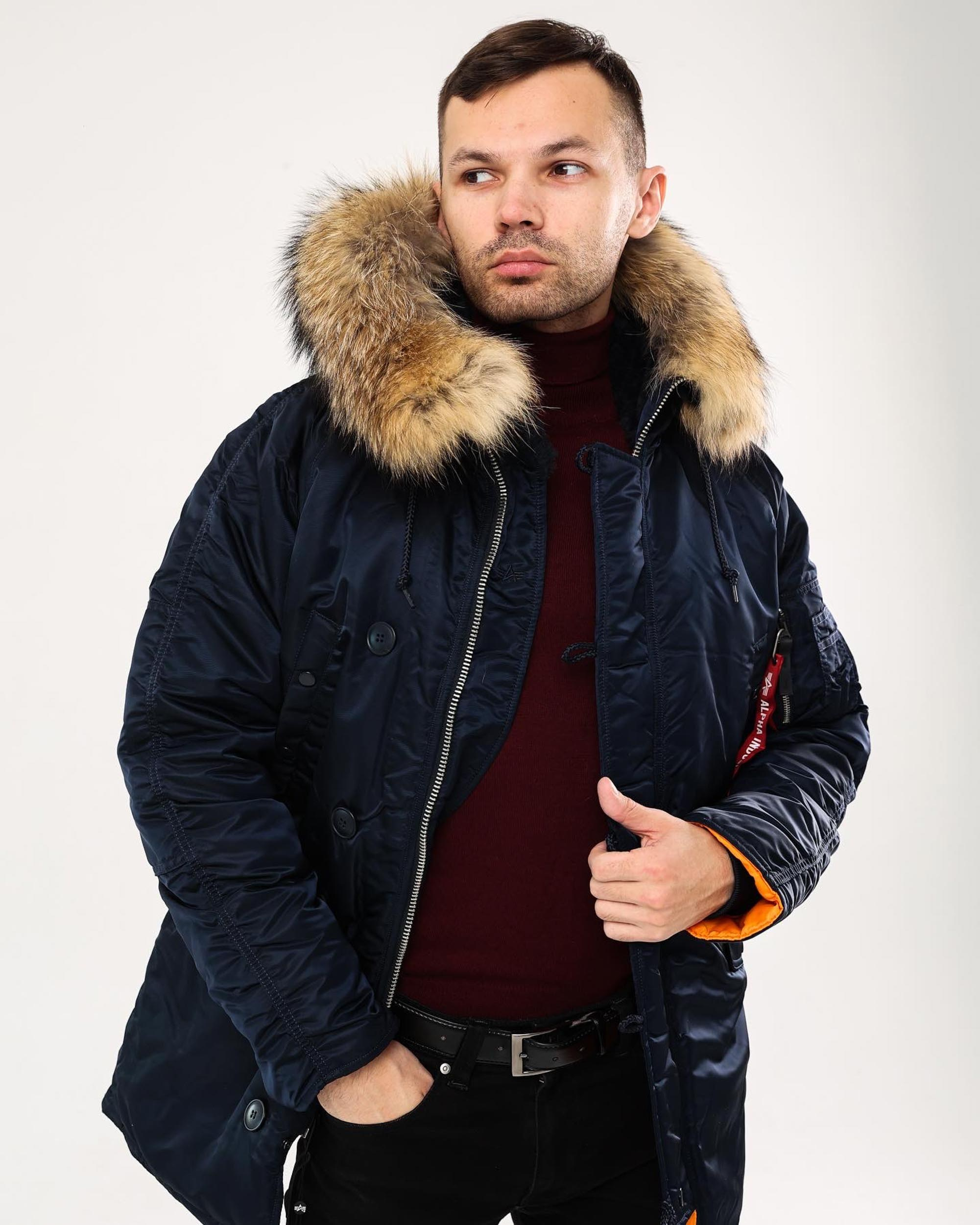 Мужчина в теплой синей куртке с капюшоном с мехом