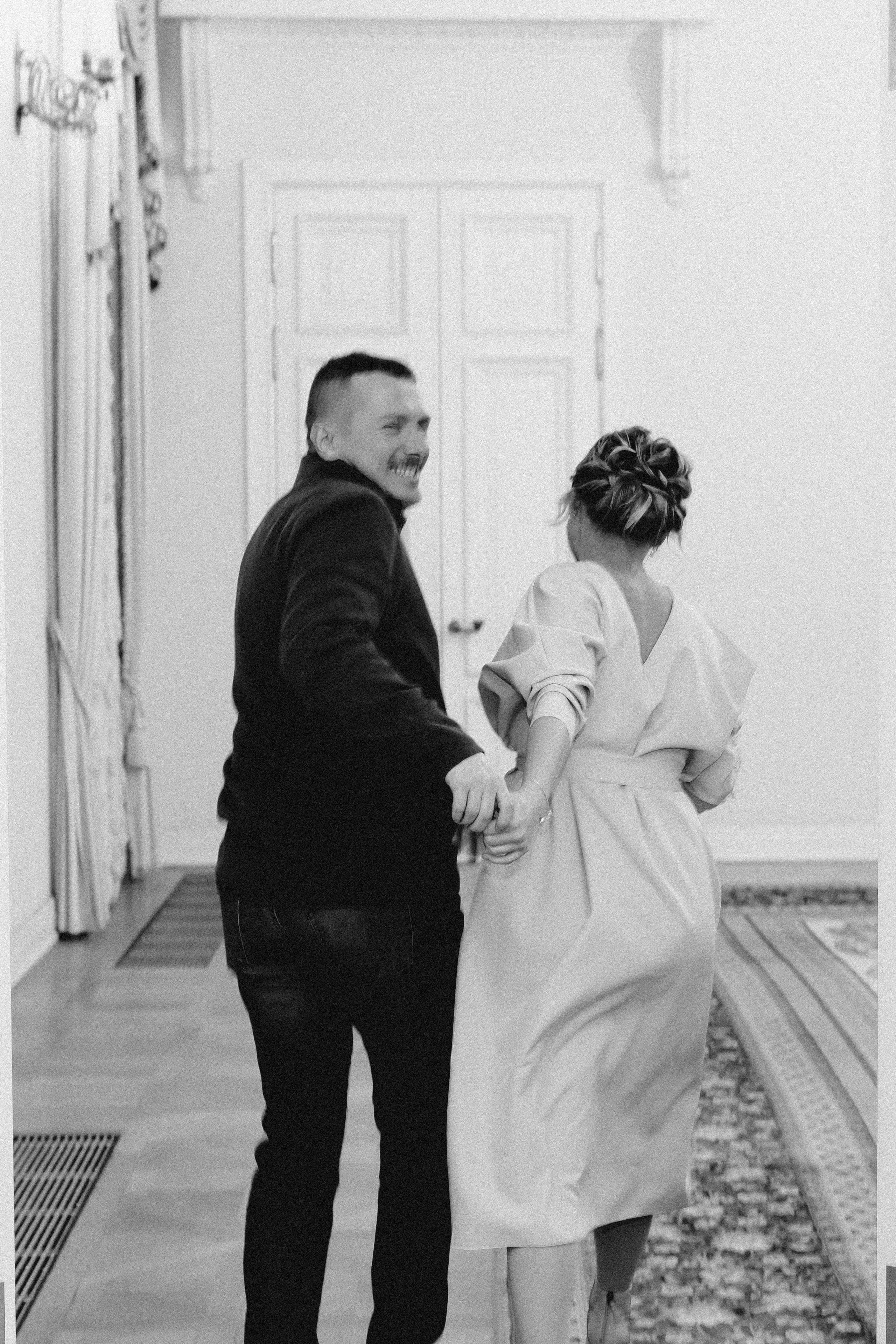 Молодожены после бракосочетания бегут, жених оборачивается