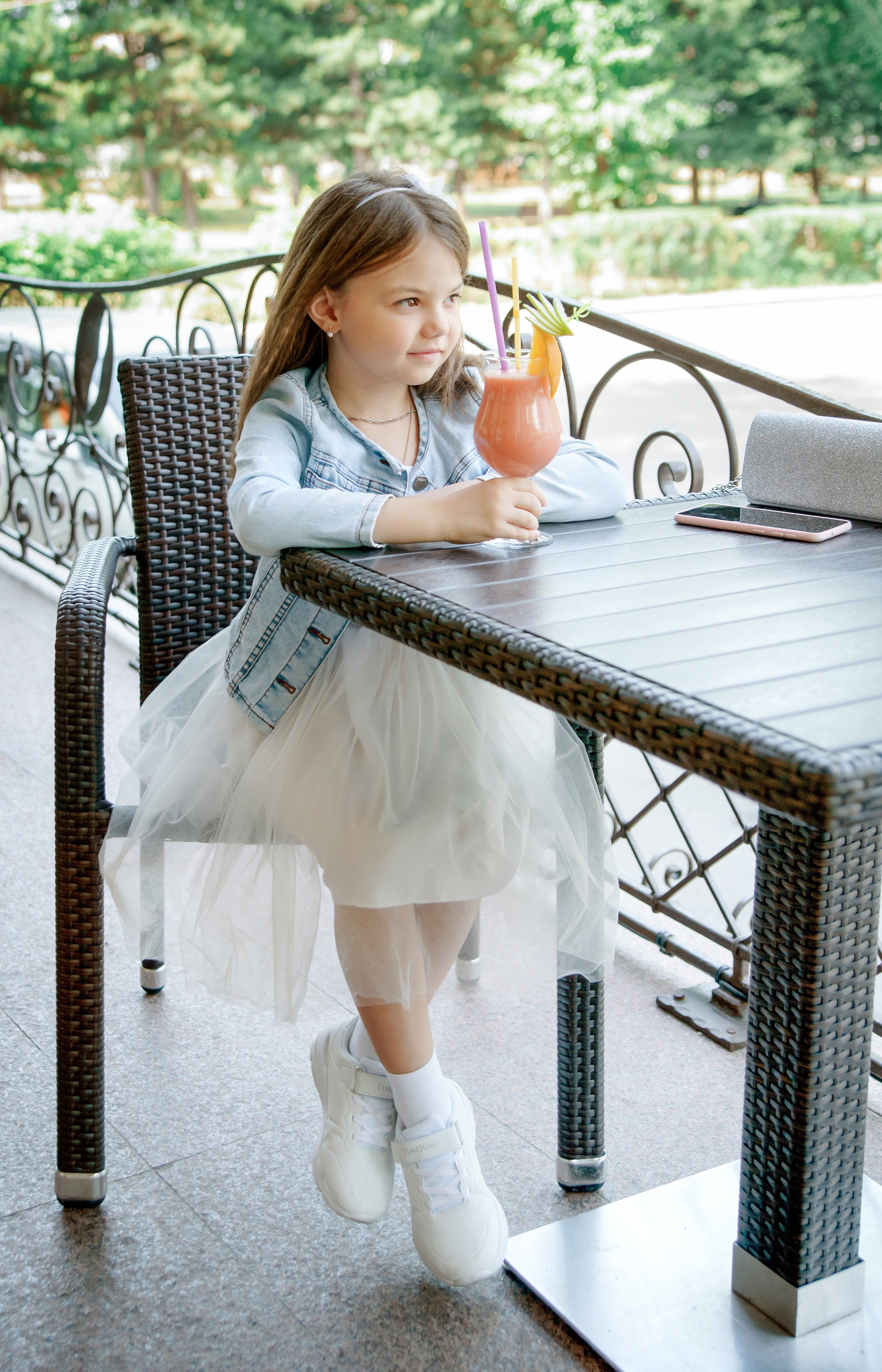 Детская фотосессия летом - девочка сидя за столиком в кафе