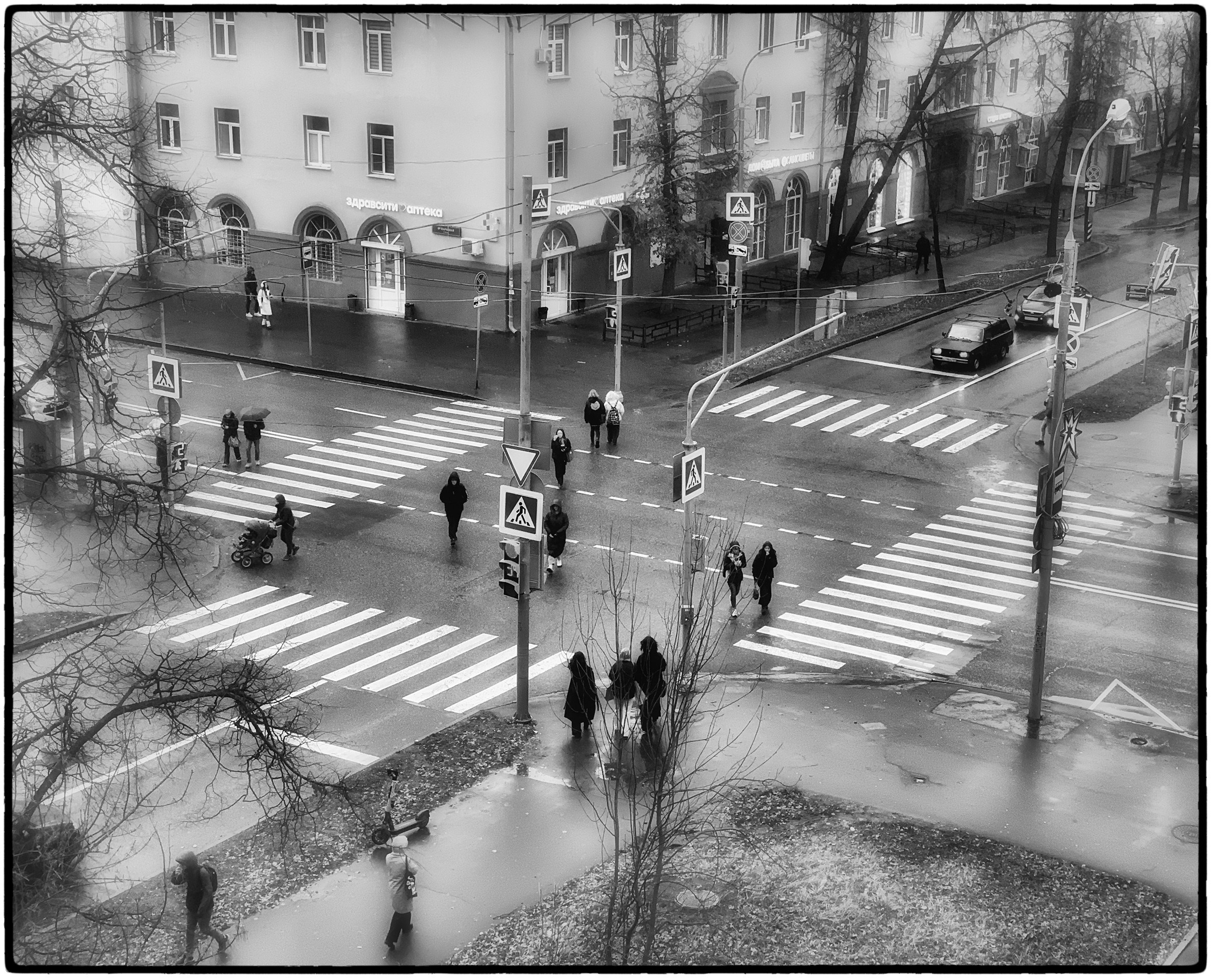 Дождь в городе, пешеходы переходят оживленный перекресток.